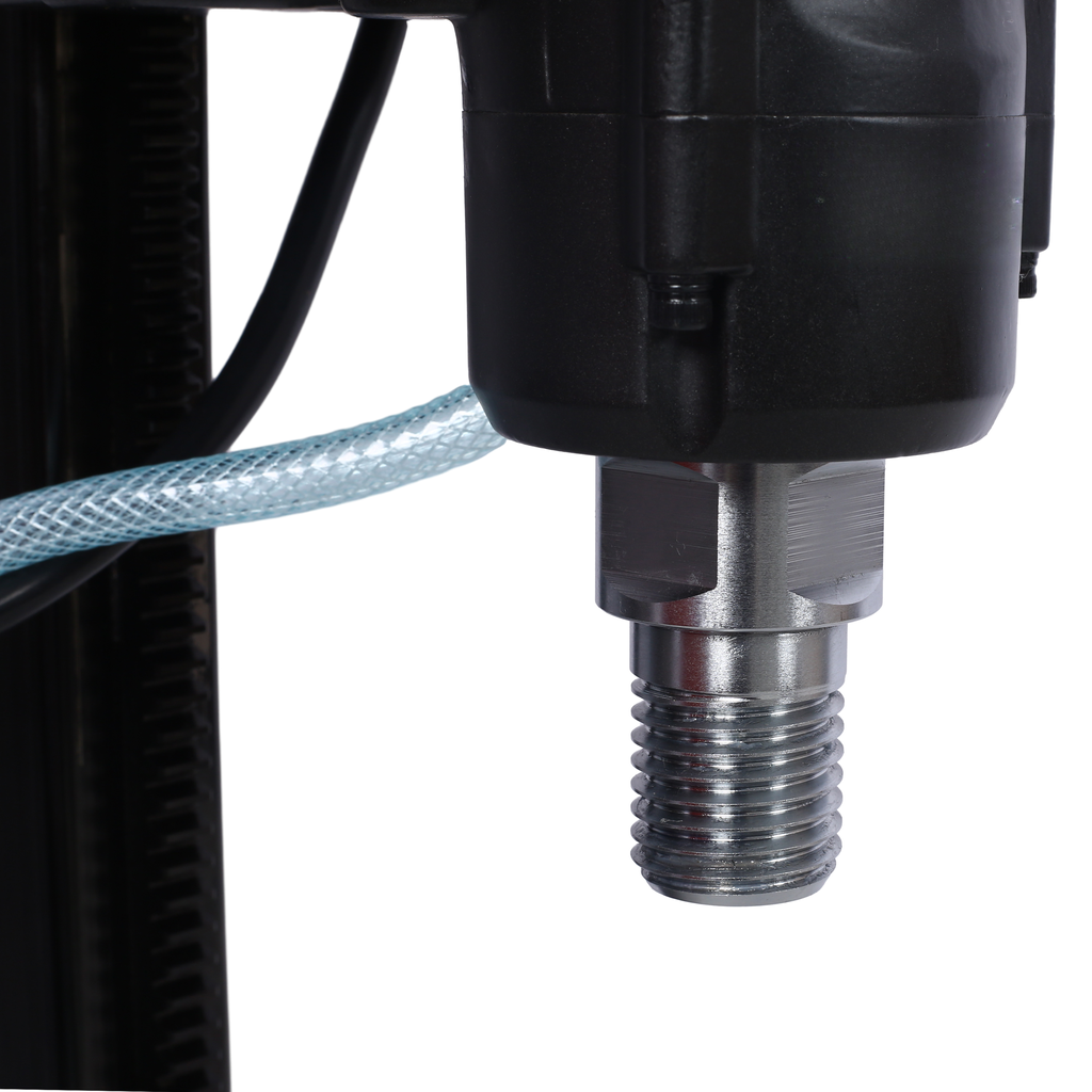 Closeup of a core drill spindle with threaded end and water hose