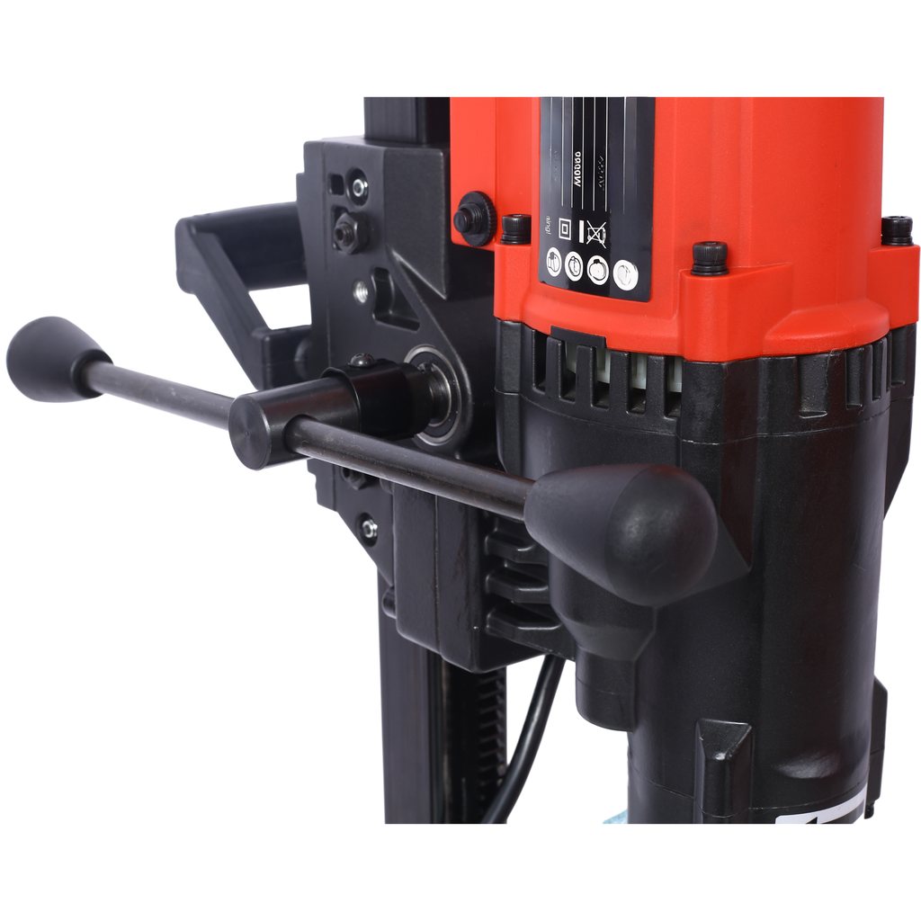 Closeup of a red and black magnetic drill with two handles for operation