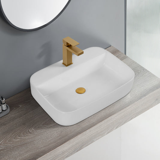 Rectangular white ceramic vessel sink with matte gold faucet and drain