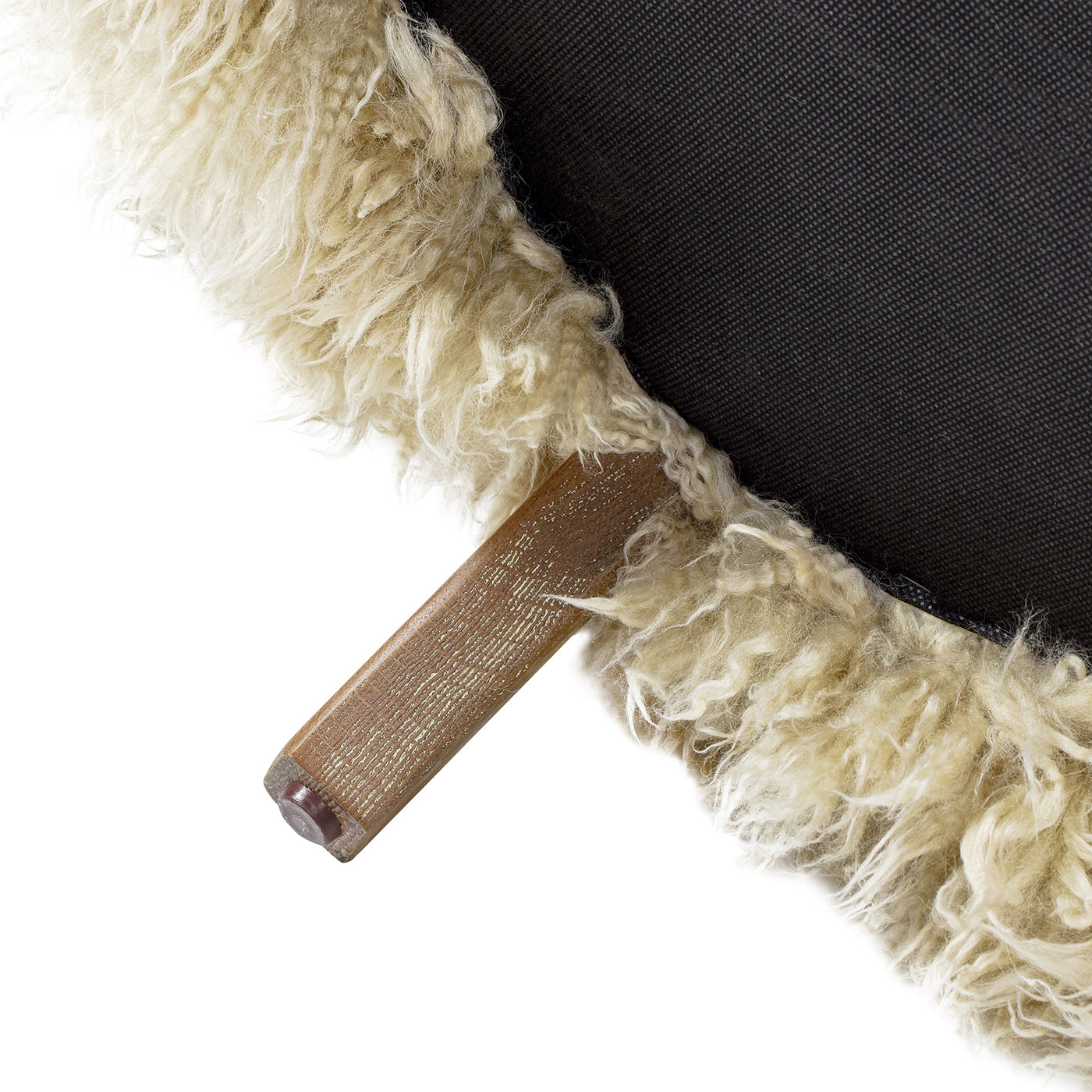 Creamy sheepskin upholstery detail with a wooden leg and brown foot  chars