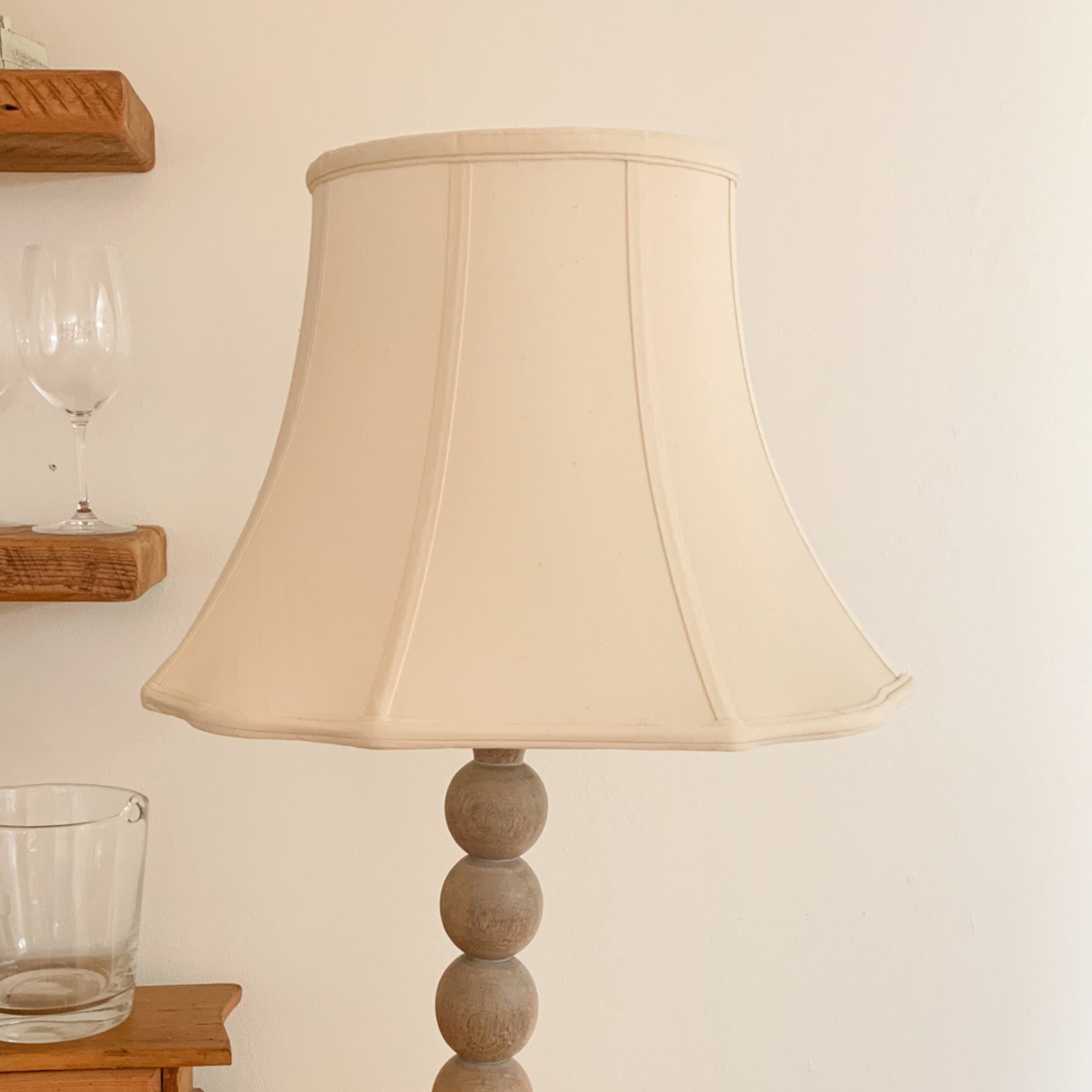 Cream fabric lampshade on a wooden ballstack base floor lamp