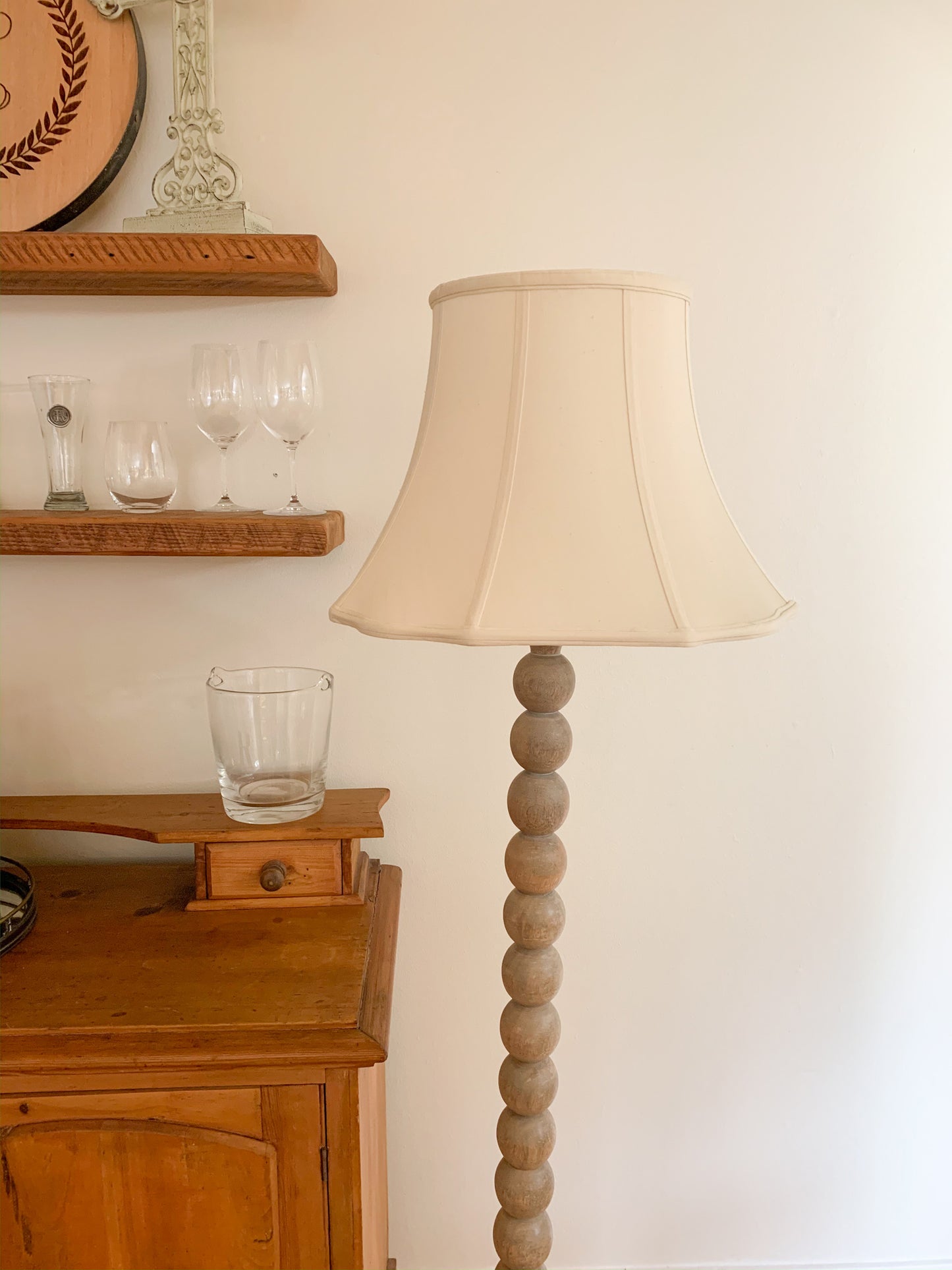 Wooden beaded floor lamp with a cream fabric shade perfect for ambient lighting