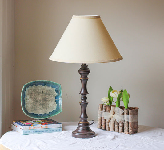 Ornate dark wood table lamp with cream fabric shade and gold accents