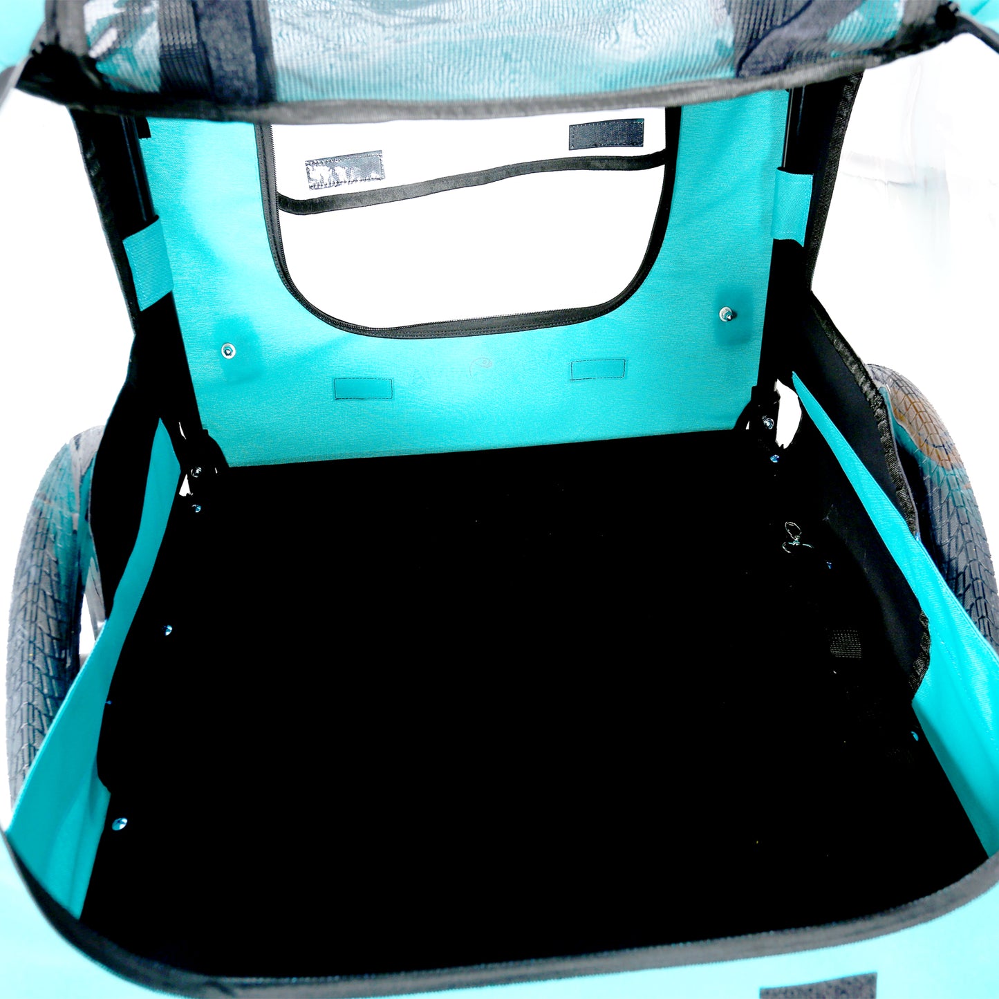Teal interior of a baby stroller trailer with black floor and mesh canopy
