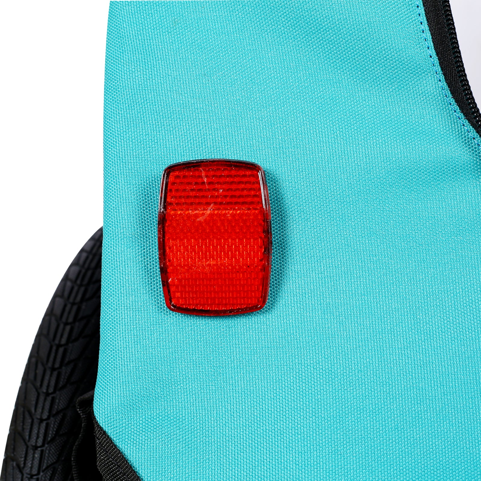 Teal backpack with a red reflector for improved visibility
