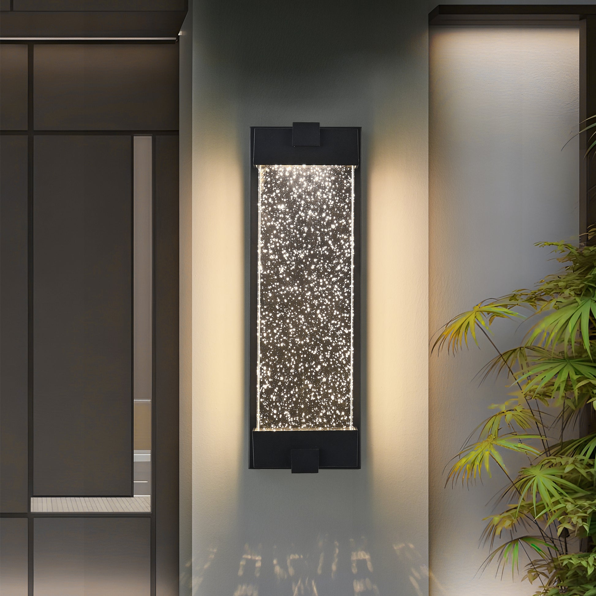 Modern black outdoor wall light with a clear glass panel filled with illuminated bubbles