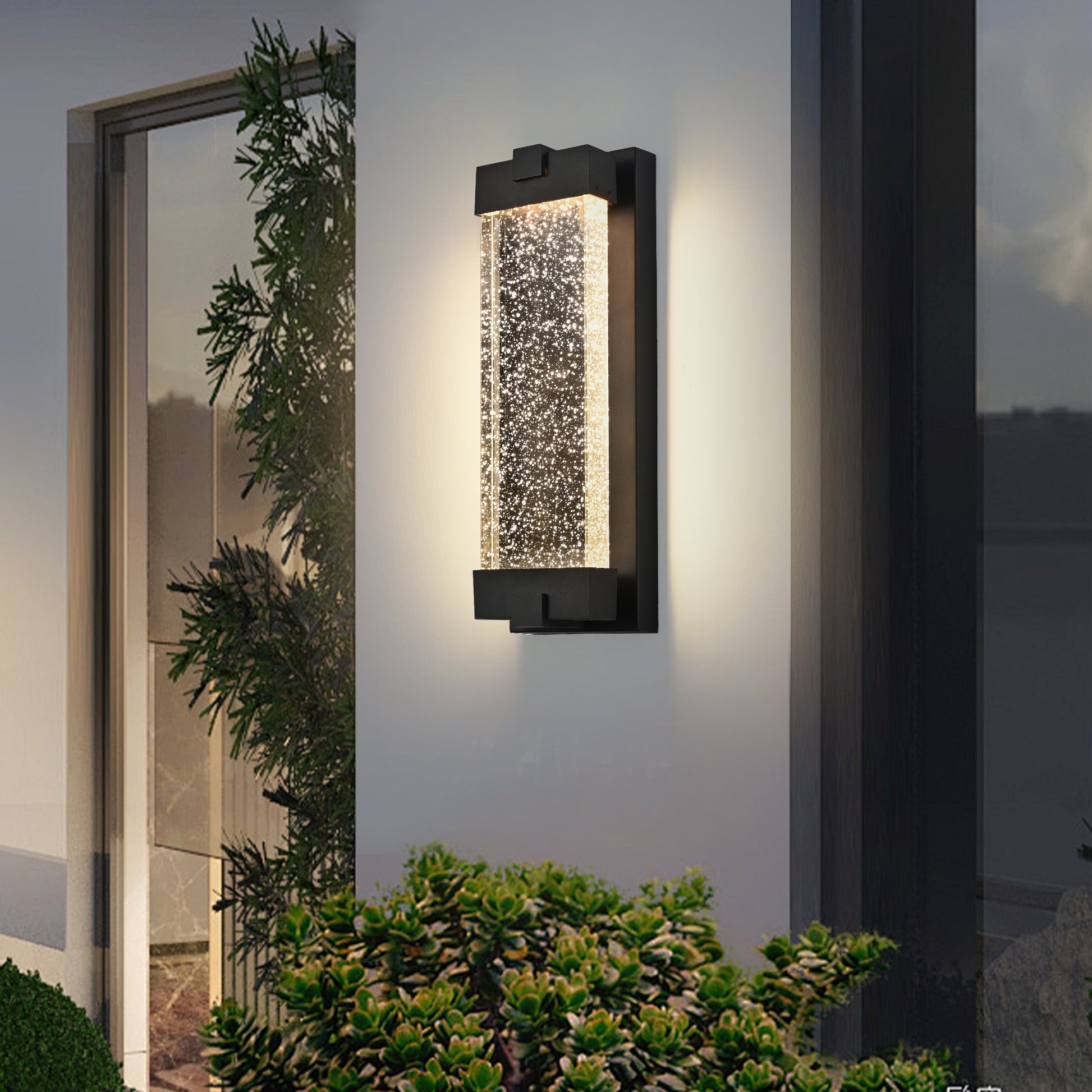 Modern black outdoor wall light with clear bubbled glass cylinder and warm LED illumination