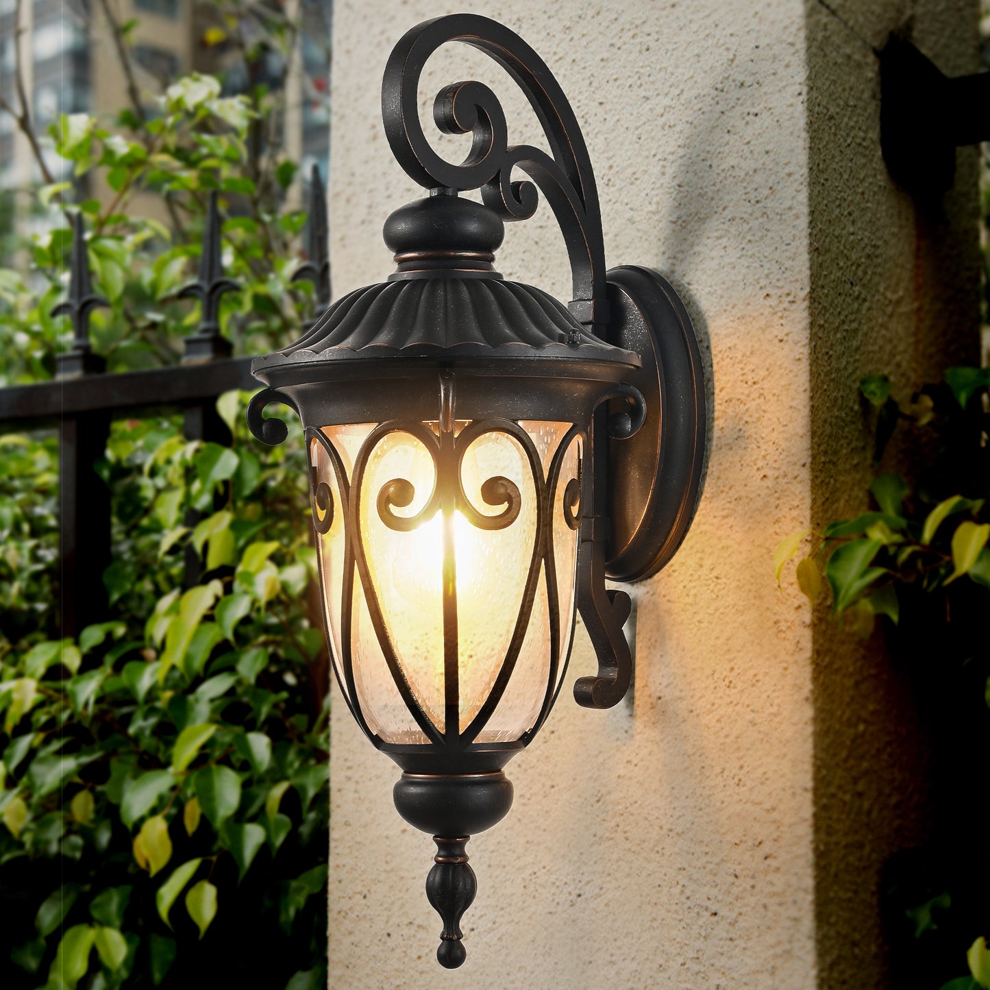 Ornate black outdoor wall lamp with seeded glass and scroll details providing warm porch lighting