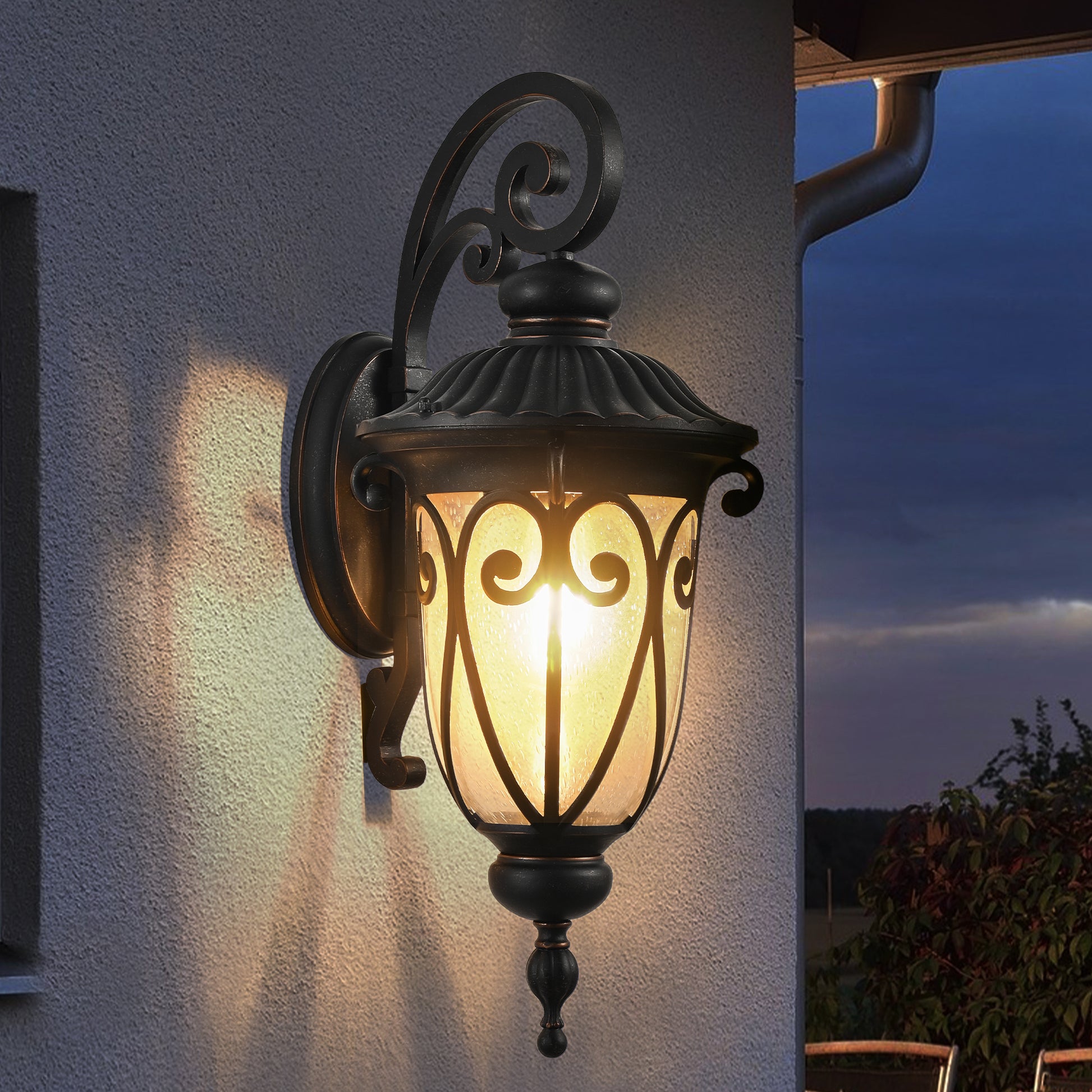 Classic black outdoor wall lantern with ornate scrollwork and seeded glass