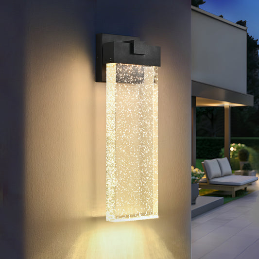 Modern black outdoor wall light with a clear glass cylinder containing bubble accents