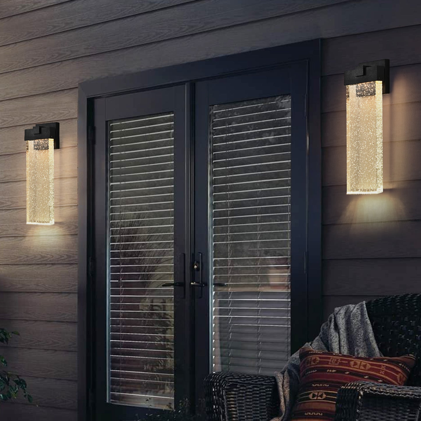 Modern outdoor wall light with clear seeded glass and black metal frame providing ambient lighting