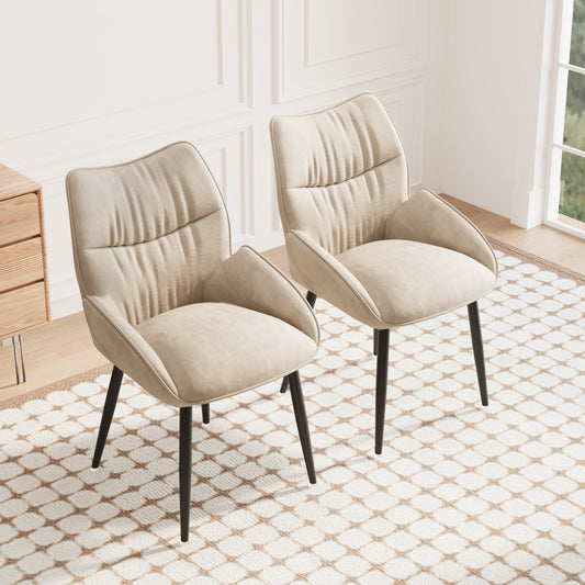 Two modern beige upholstered dining chairs with dark tapered legs sit on a cream and brown patterned rug