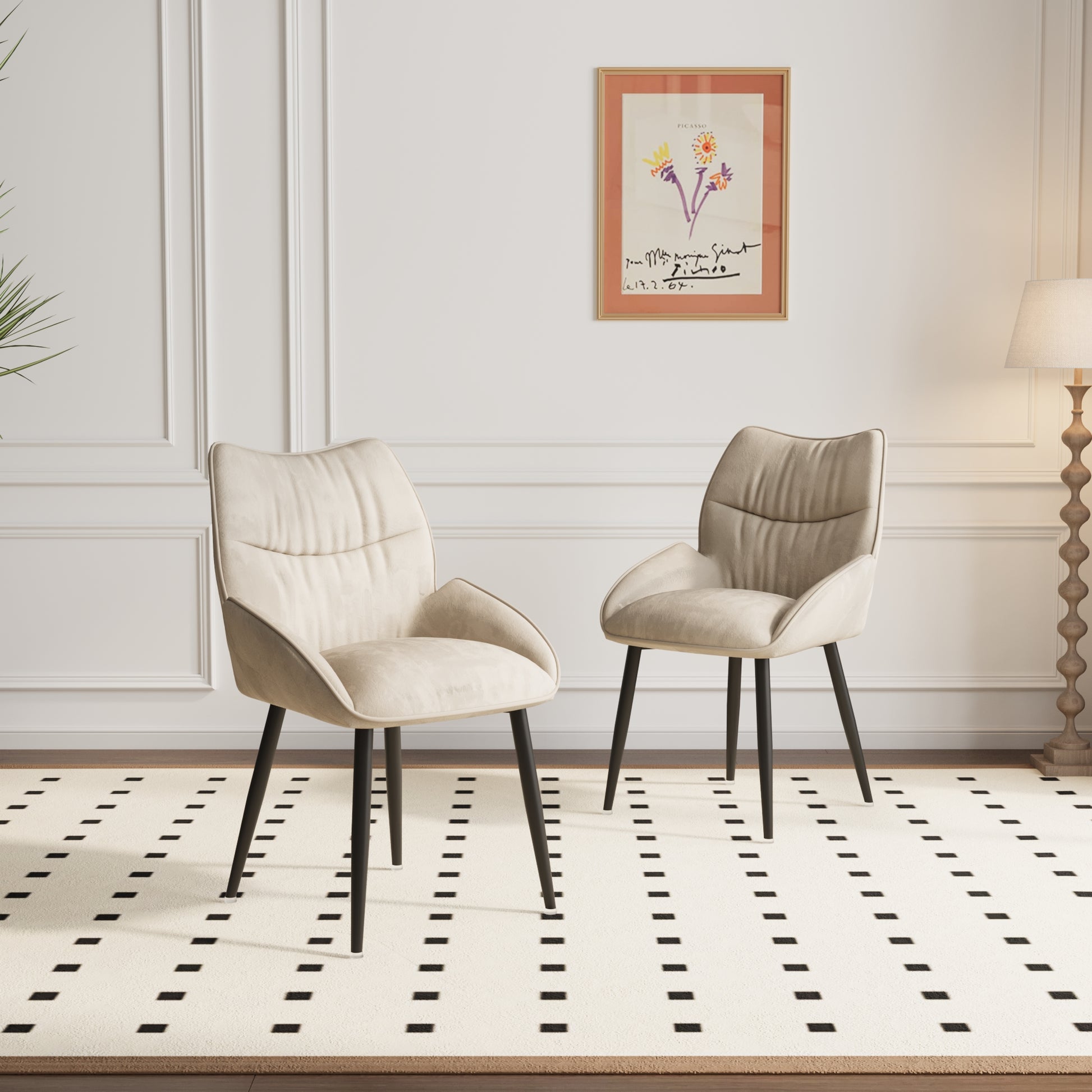 Two plush beige dining chairs with black legs on a cream rug with black dashes