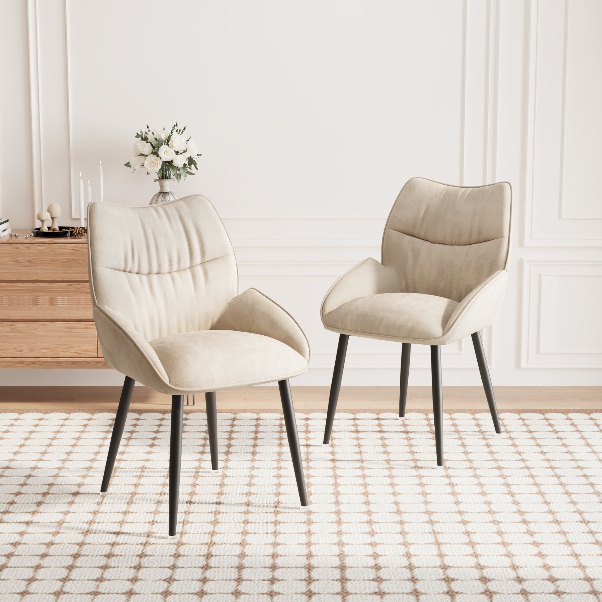 Two upholstered beige accent chairs with dark legs on a cream rug