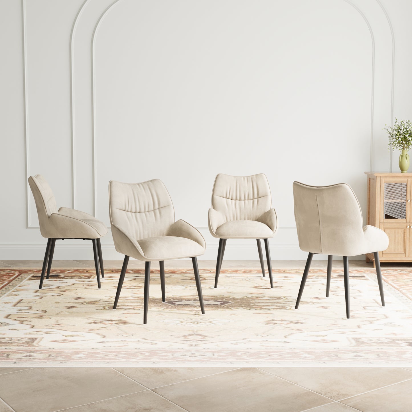 Four beige upholstered dining chairs with black metal legs on an ornate rug
