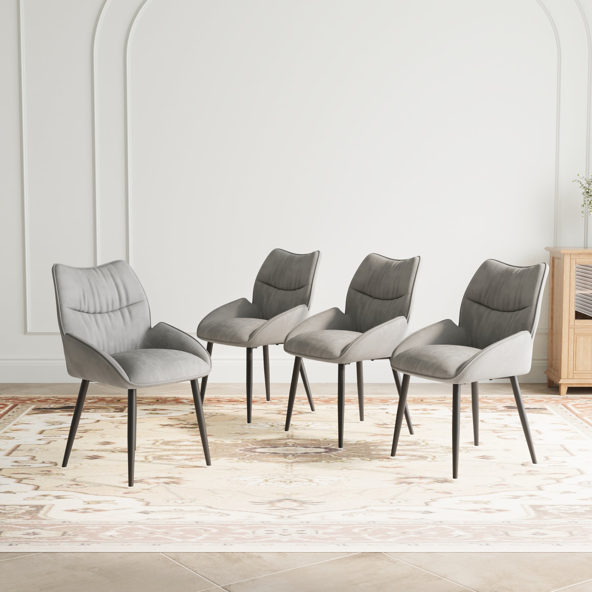 Set of four grey velvet dining chairs with black metal legs