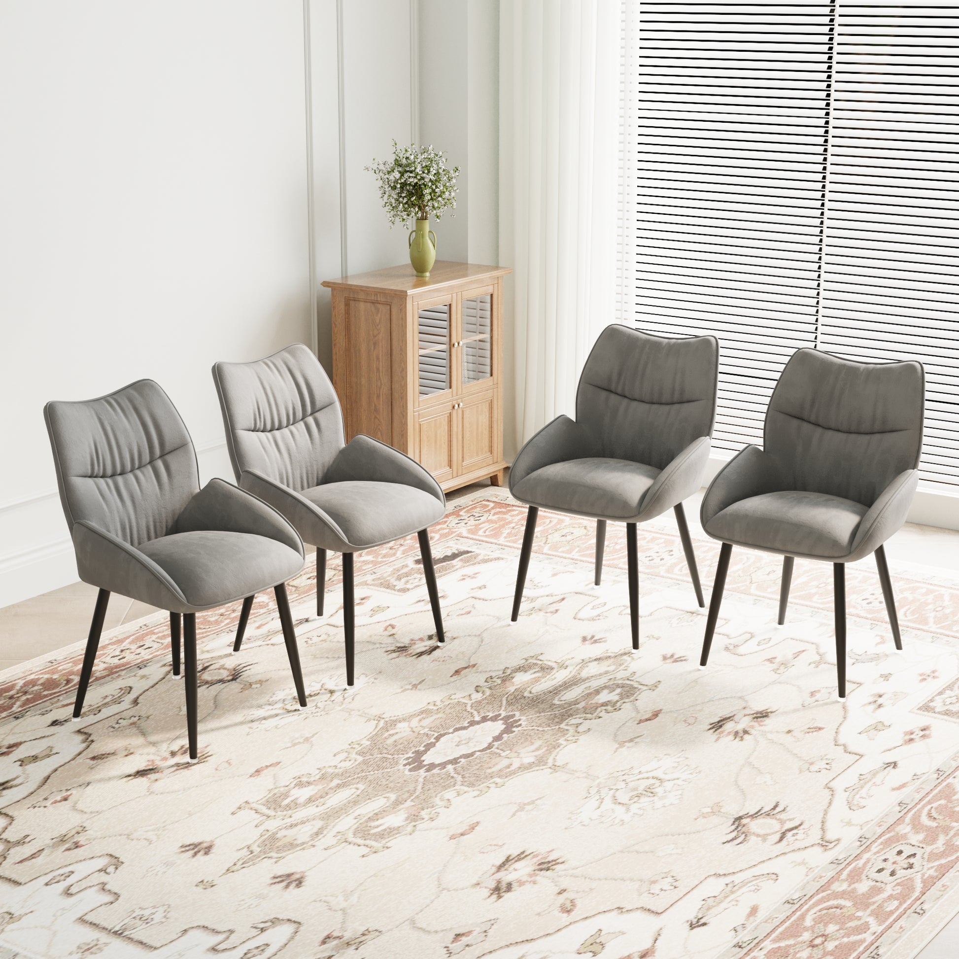 Set of four grey velvet dining chairs with black metal legs providing a modern accent