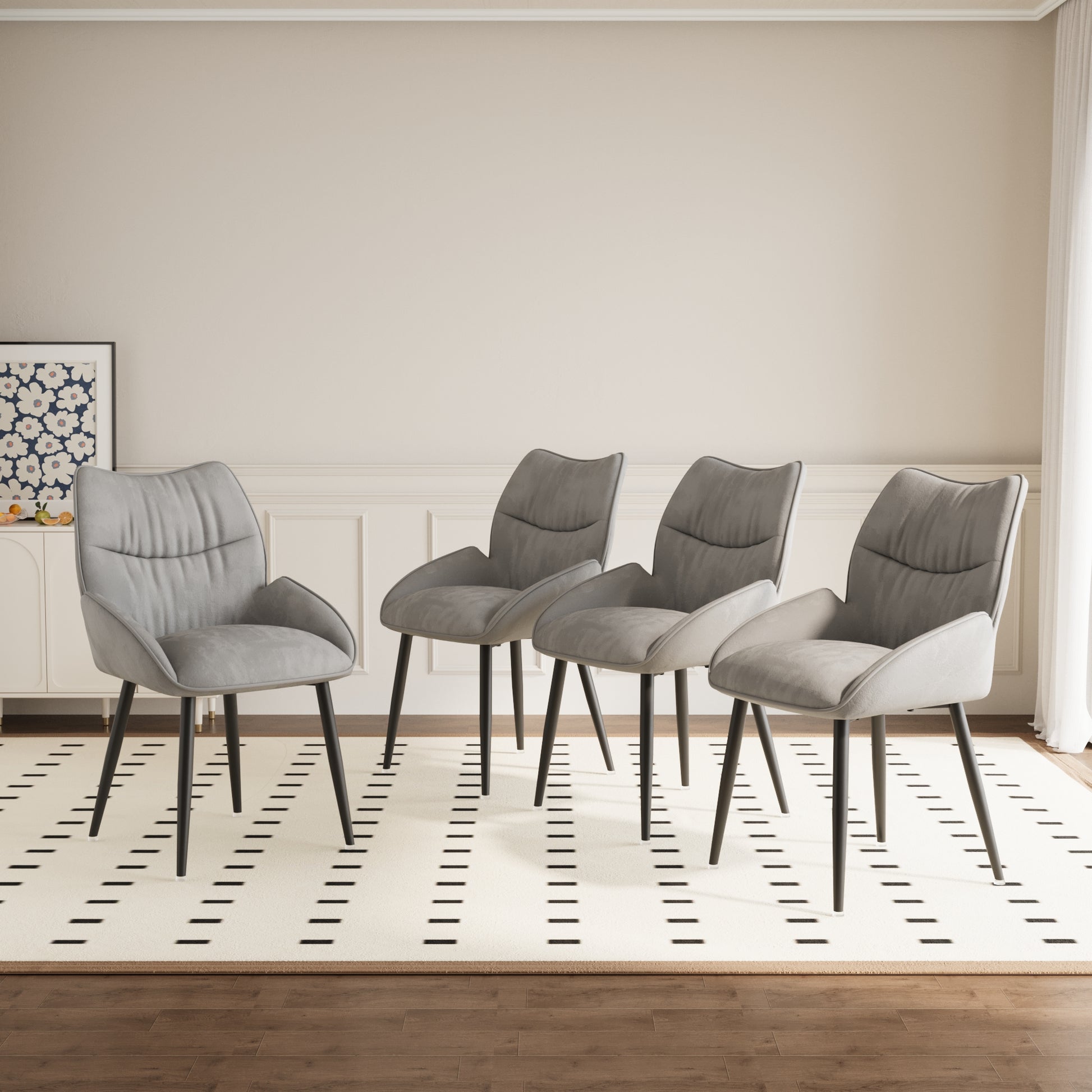 Four grey fabric dining chairs with black tapered legs on a cream rug