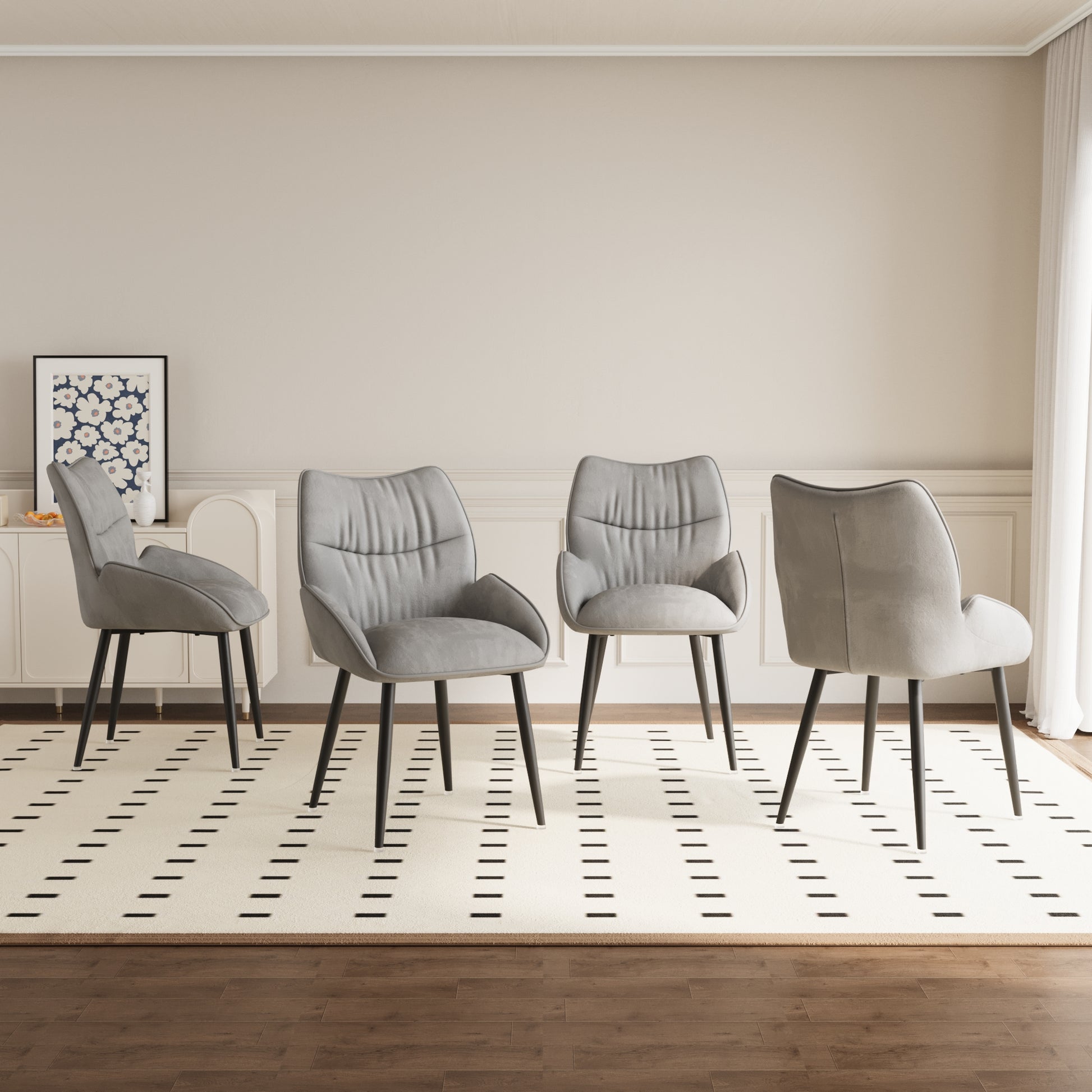 Four grey upholstered dining chairs with black legs arranged in a modern dining room