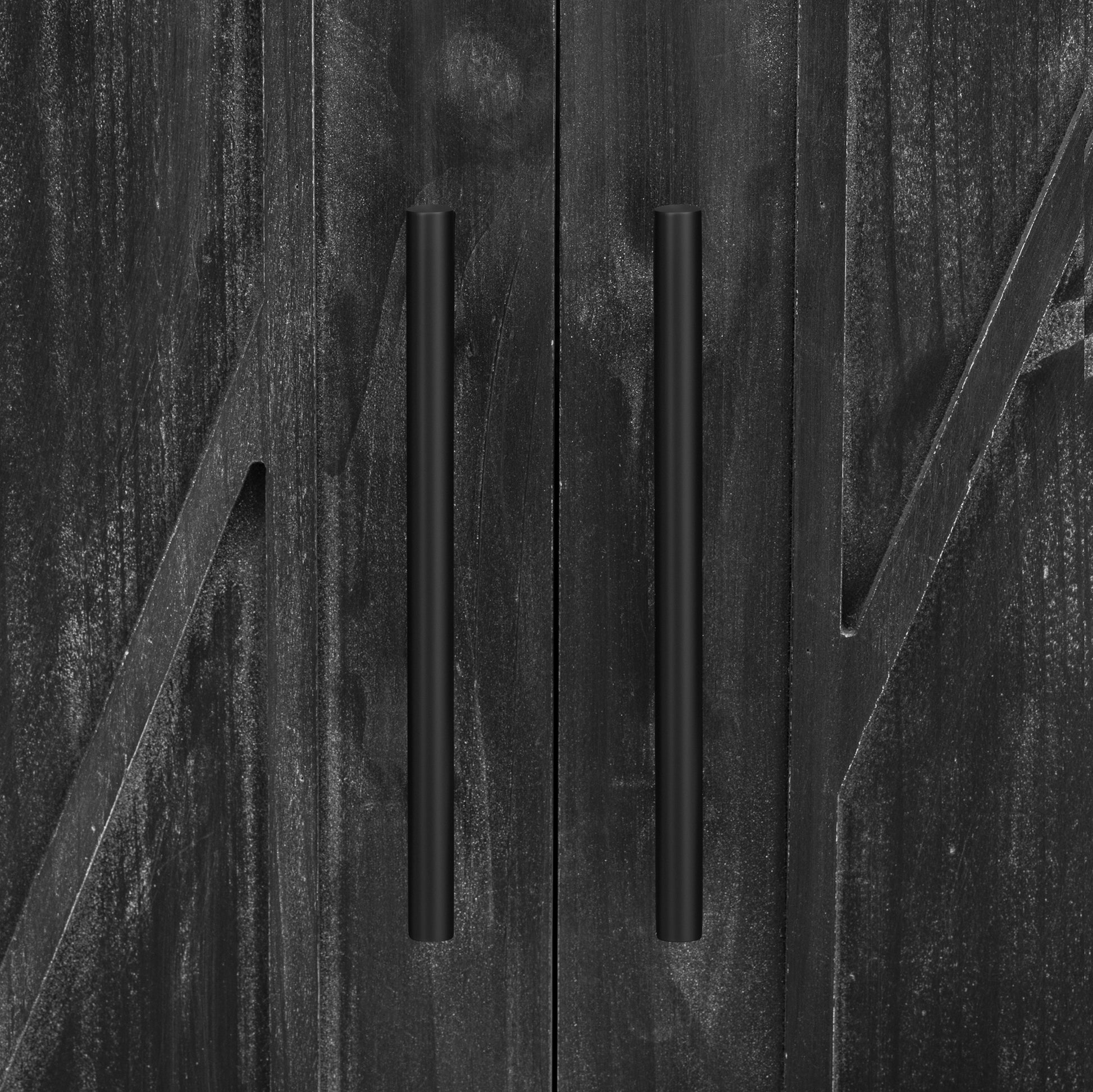 Closeup of a black distressed wood cabinet door with modern black bar pulls