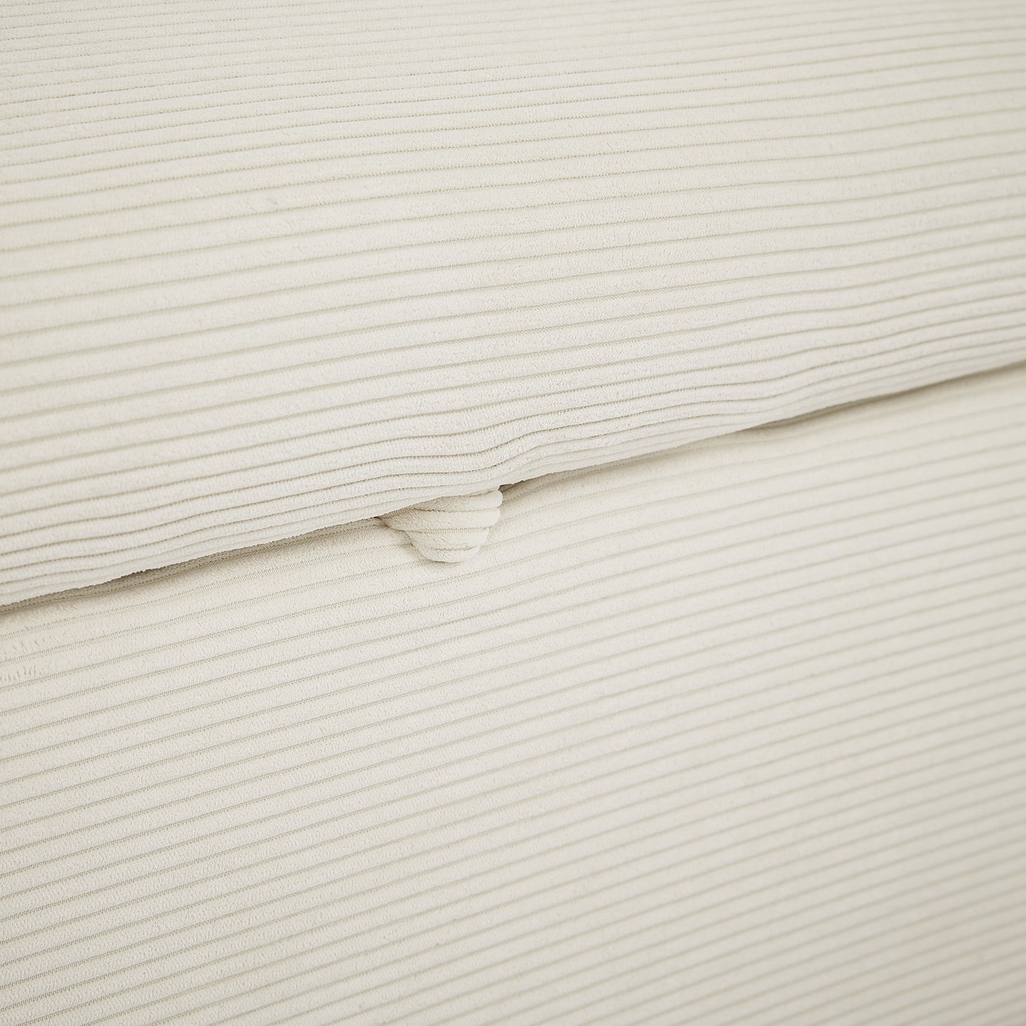 Closeup of cream corduroy fabric with subtle textured stripes