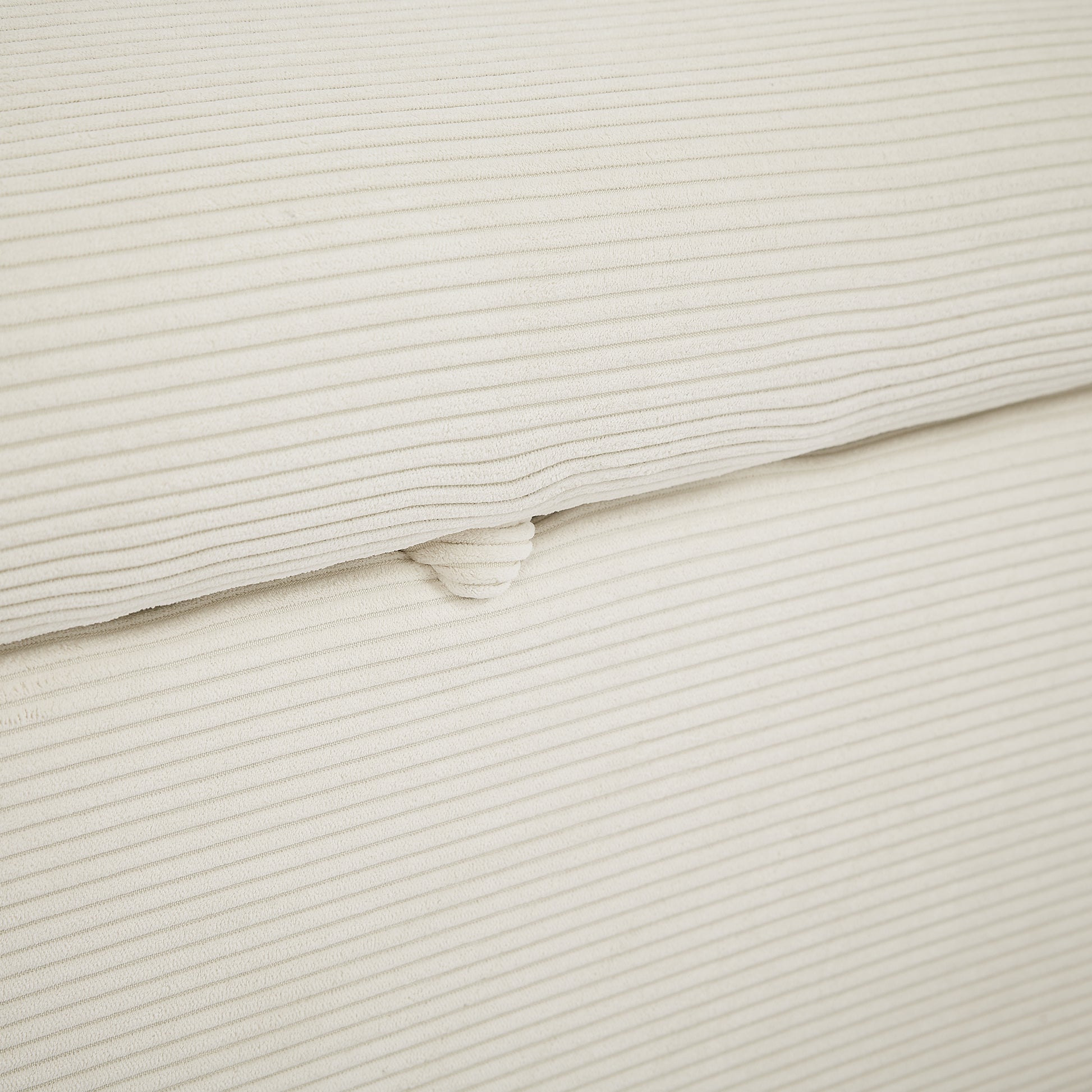 Closeup of cream corduroy fabric with subtle textured stripes