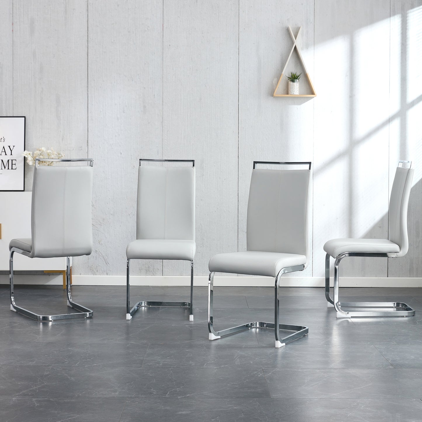 Set of four modern grey faux leather dining chairs with chrome sled bases