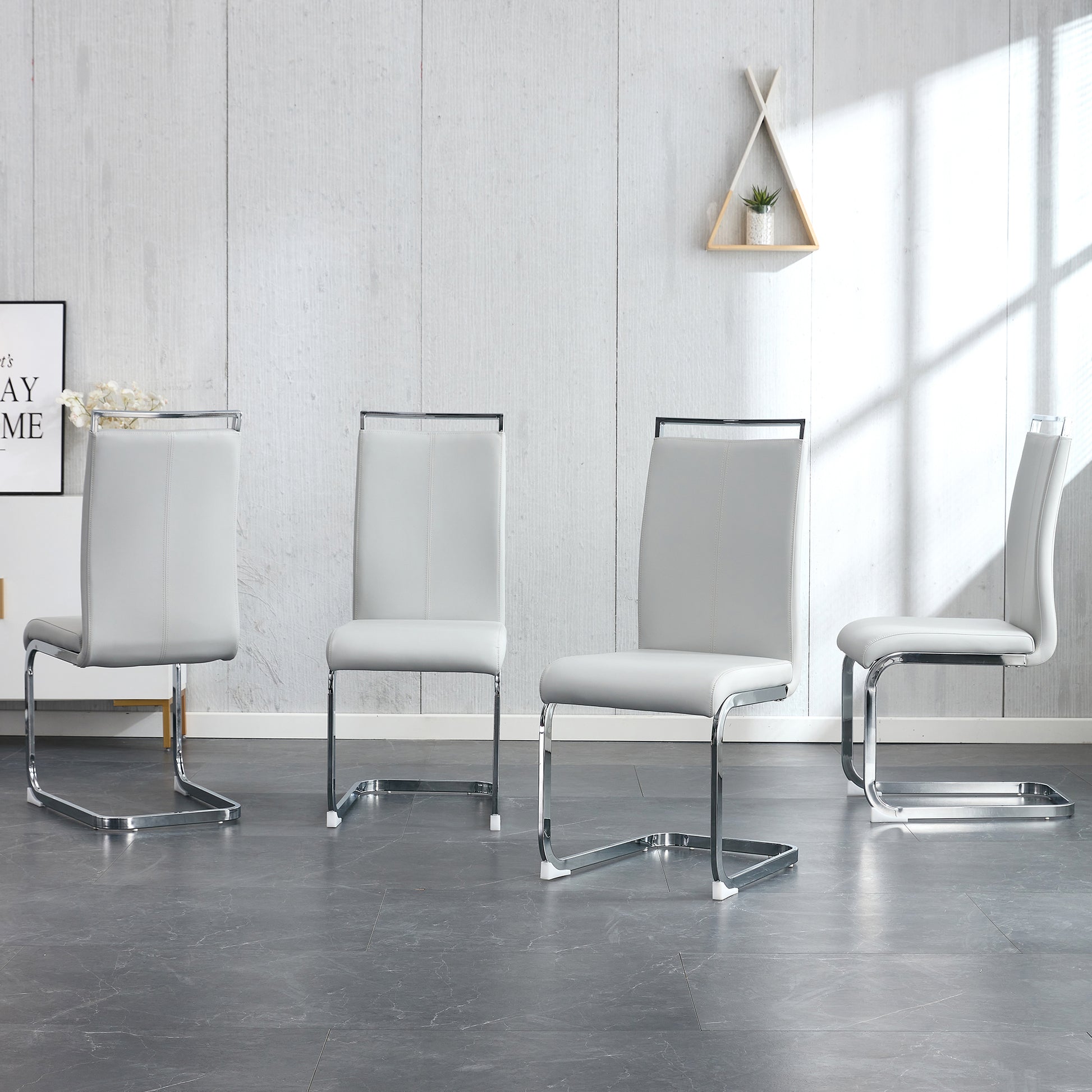 Set of four modern grey faux leather dining chairs with chrome sled bases