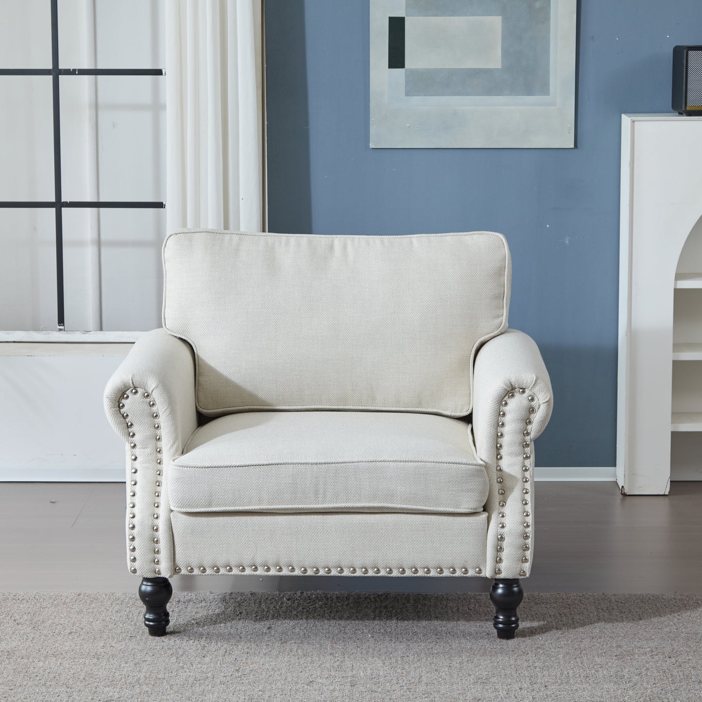 Cream upholstered armchair with nailhead trim and dark wooden legs perfect for living rooms
