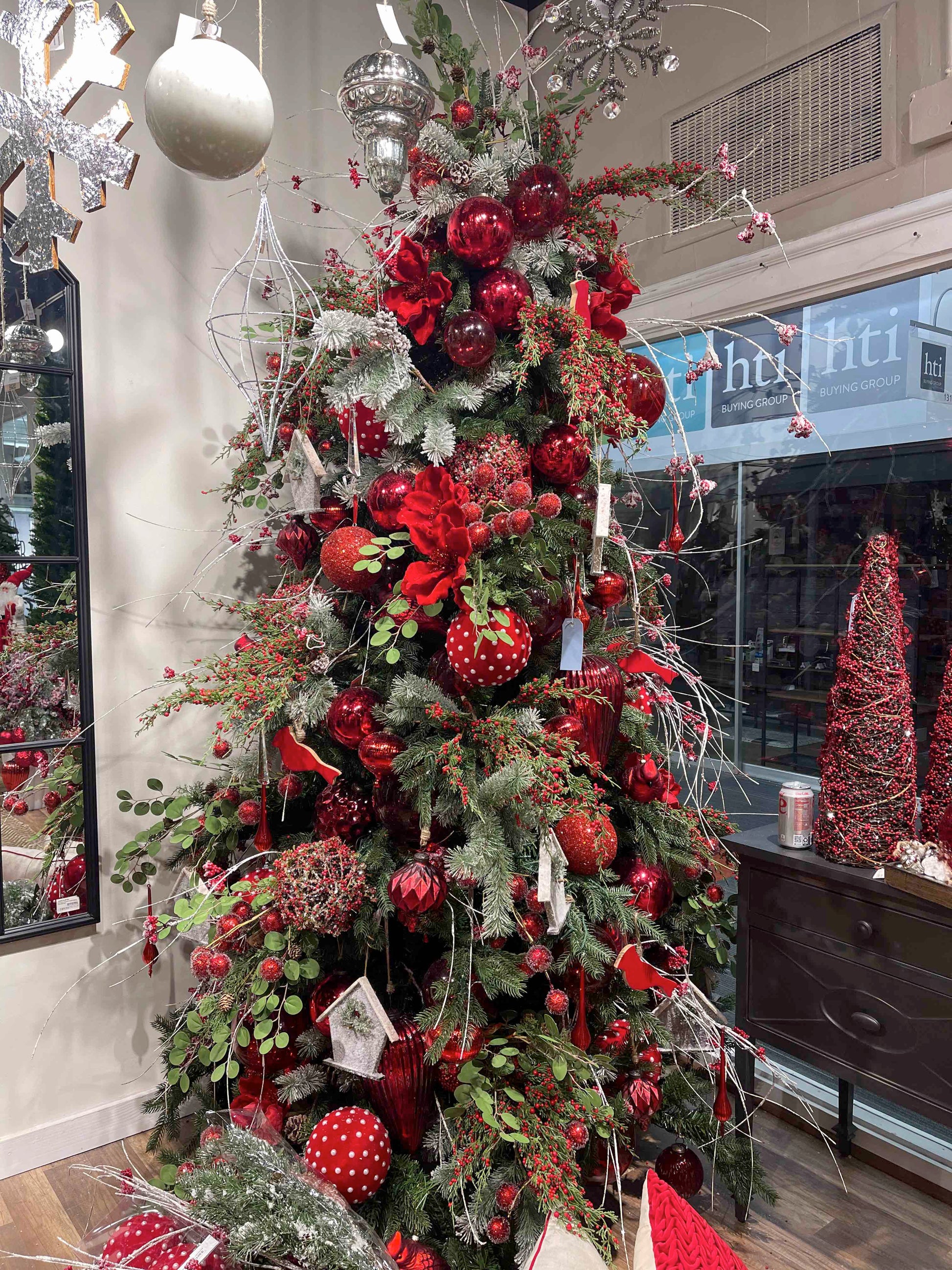 Luxurious red and gold Christmas tree with ornate baubles and faux snow