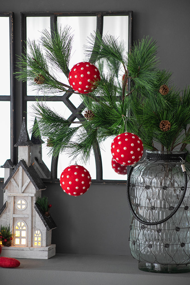 Red polka dot Christmas baubles on pine branch
