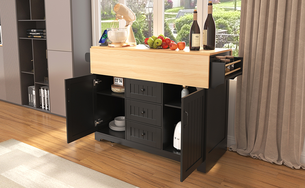 Black kitchen island with butcher block top open doors and drawers displaying dishware