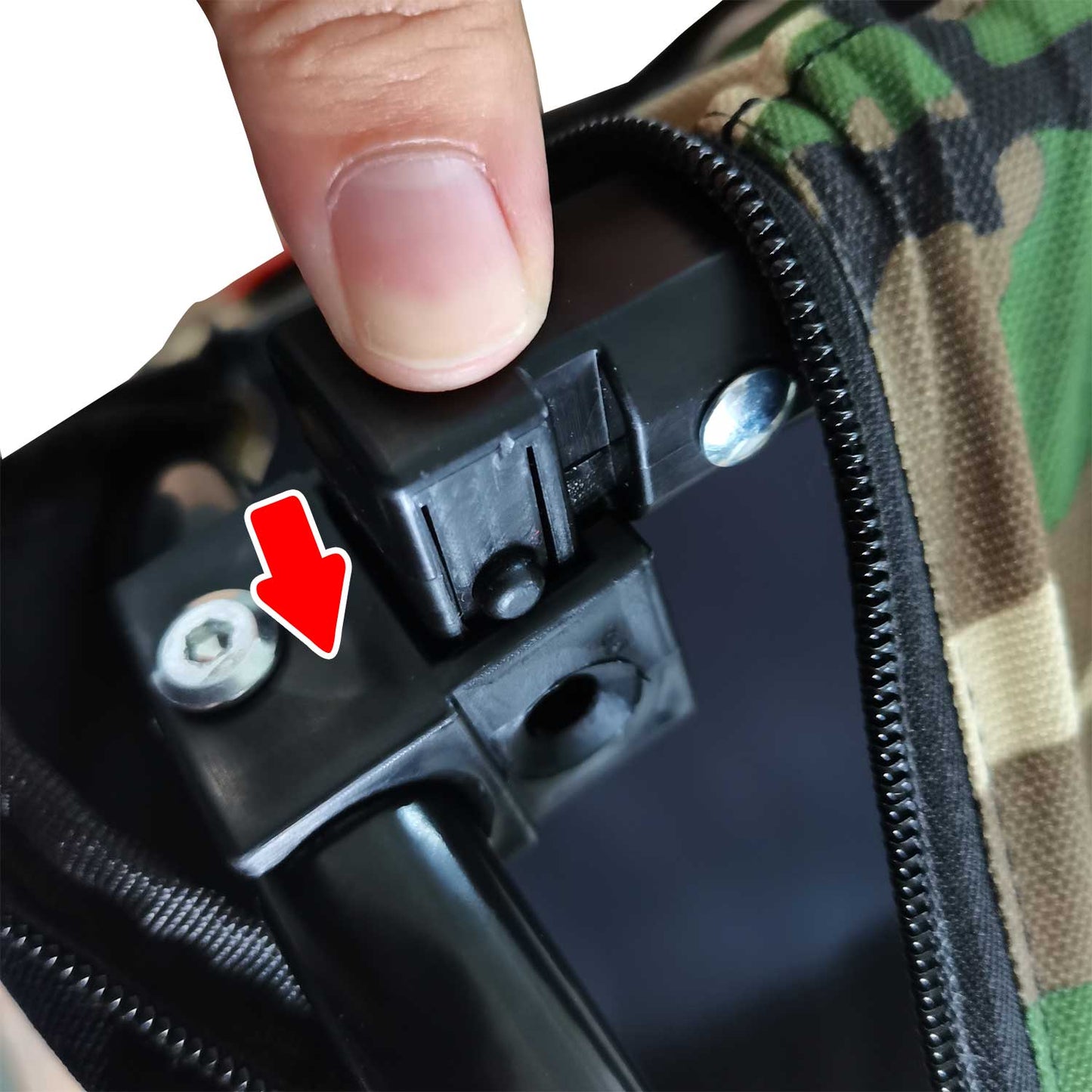 Finger presses black plastic latch on camouflage bag zipper assembly