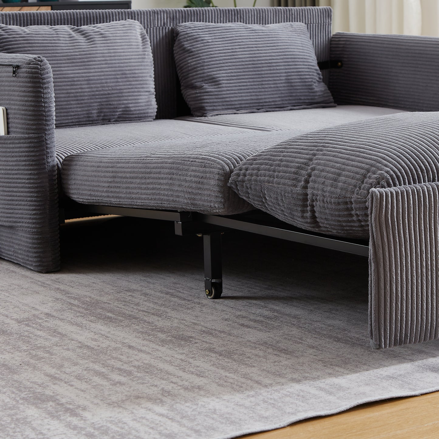 Gray corduroy sofa bed with storage pocket on armrest