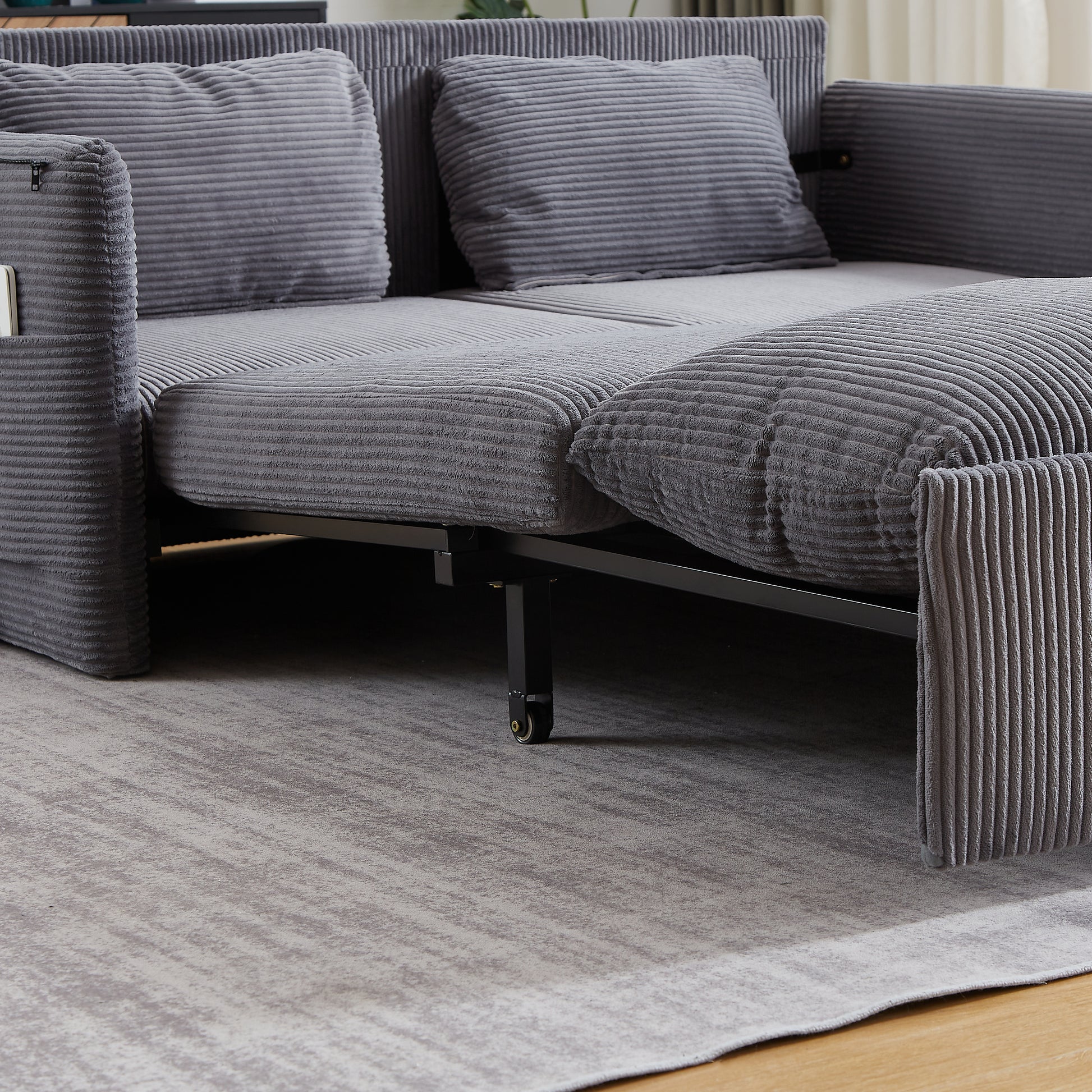 Gray corduroy sofa bed with storage pocket on armrest