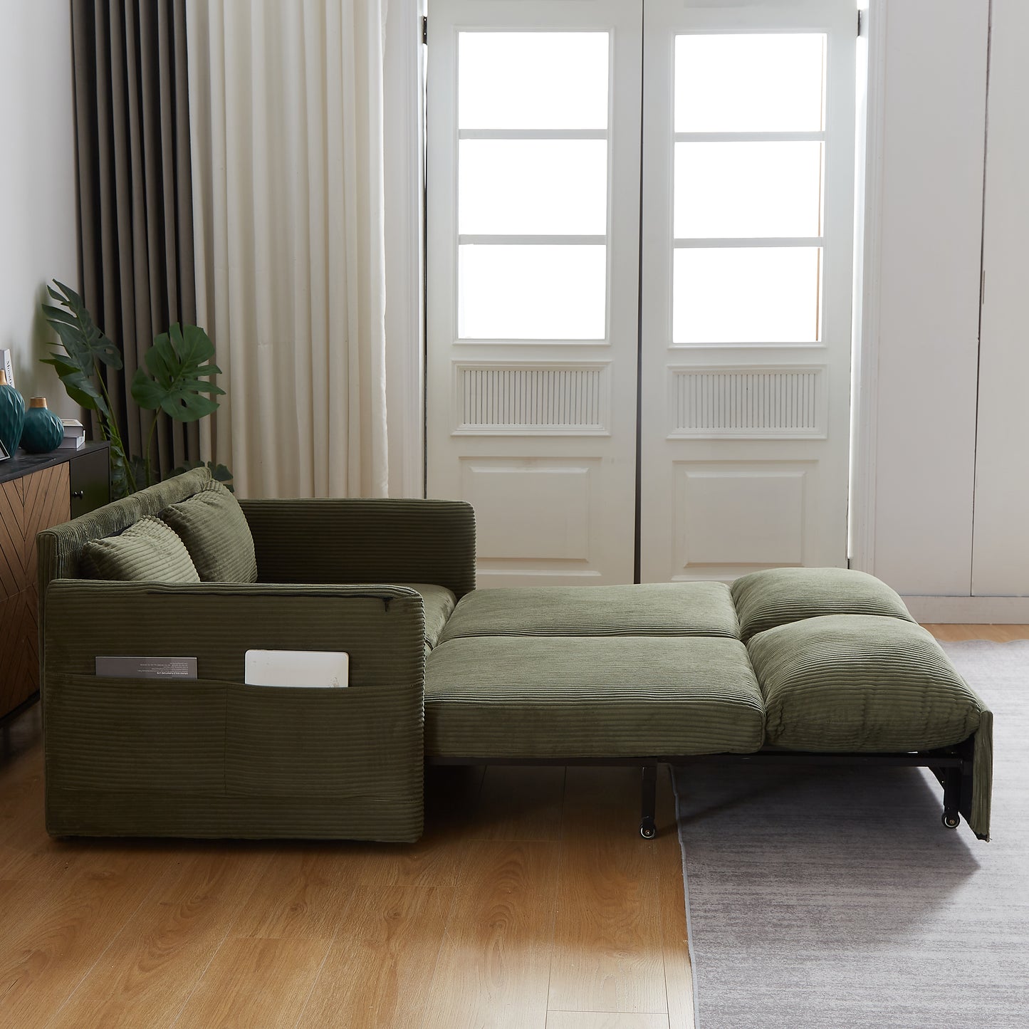 Olive green corduroy sofa bed extended featuring plush cushions and convenient side pockets for modern living