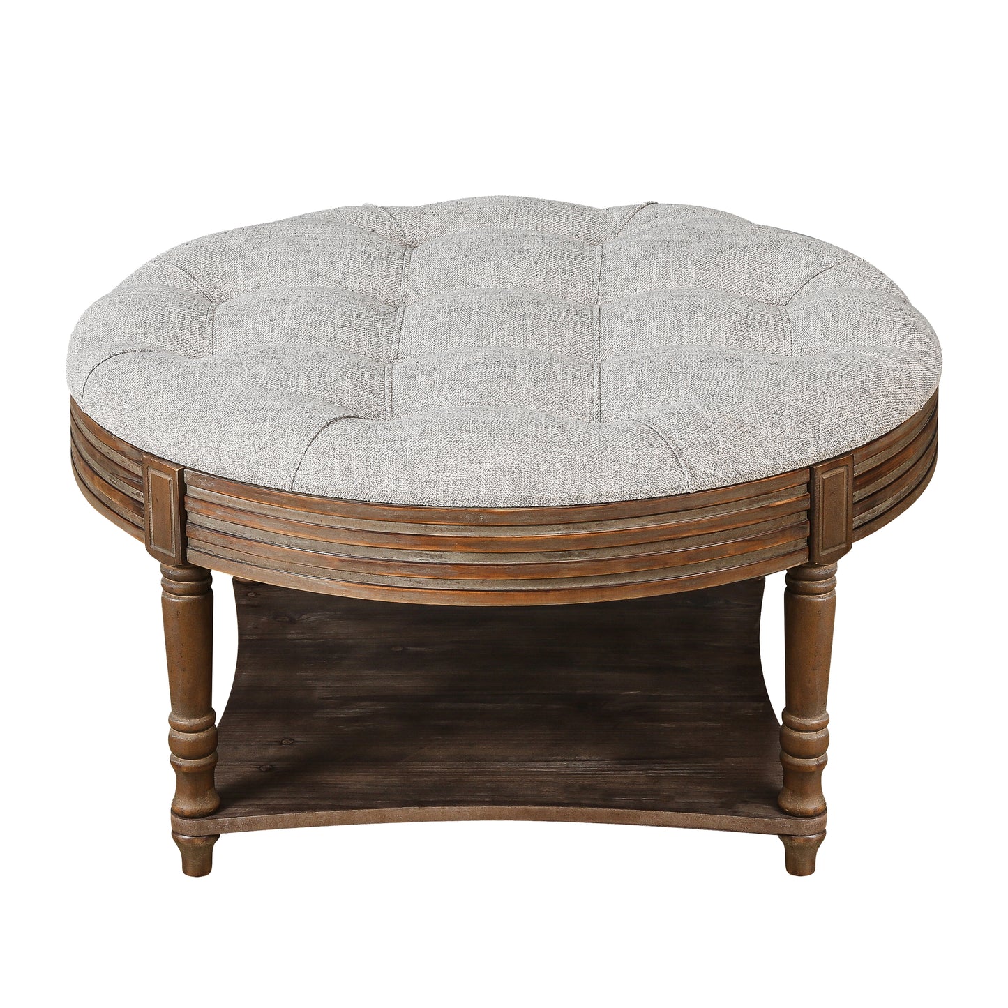 Tufted grey fabric ottoman with carved wooden base and lower shelf