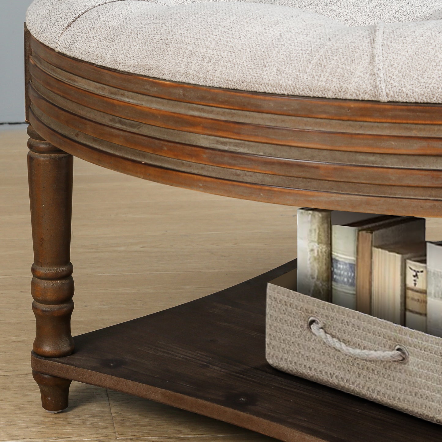 Tufted beige fabric ottoman with distressed wood trim and storage shelf