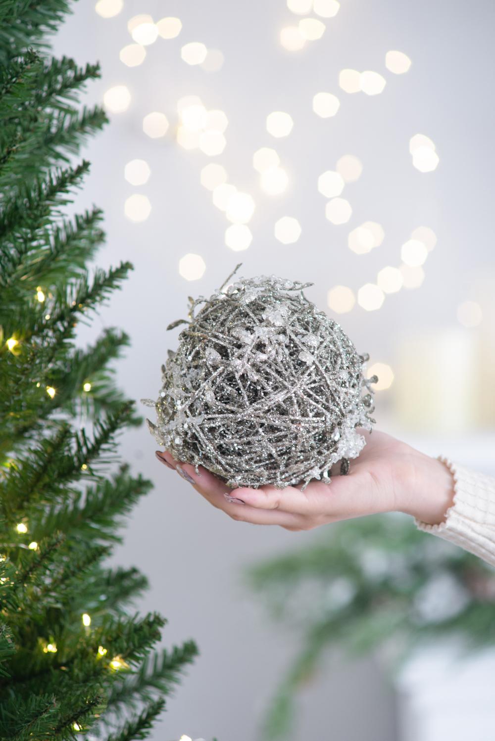 Sparkling silver glitter ball Christmas ornament with intricate twig detailing