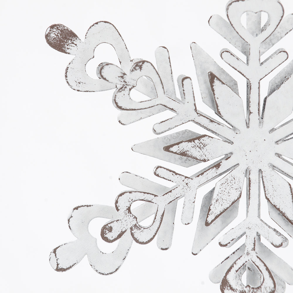 Distressed white metal snowflake ornament with rustic charm perfect for winter decor