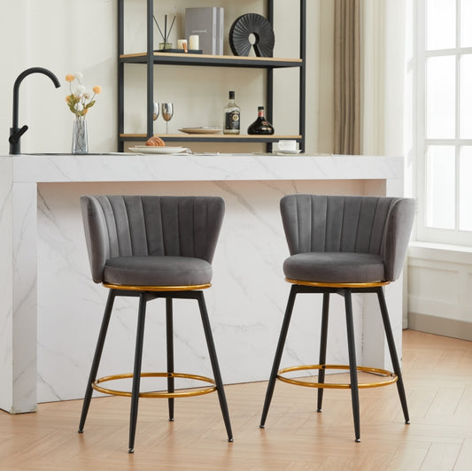 Two upholstered gray velvet bar stools with gold accents and black legs