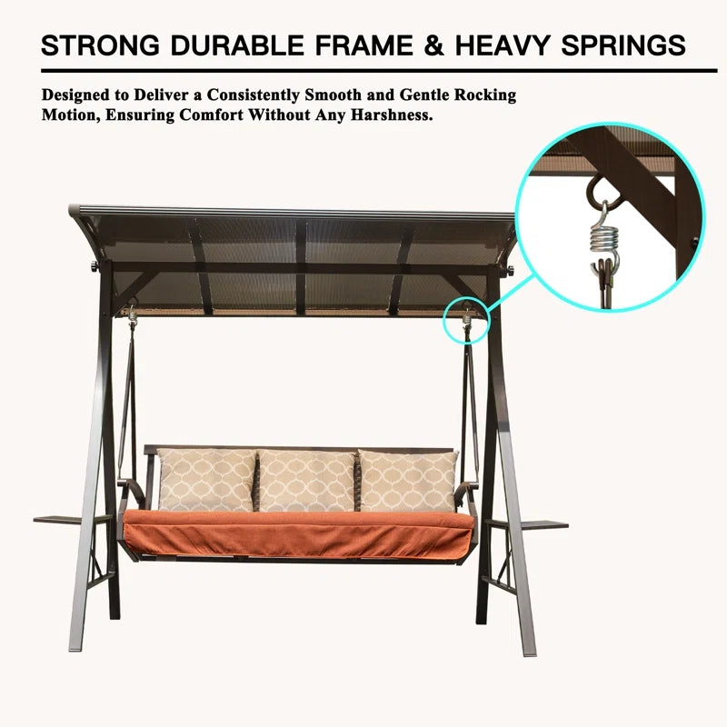 Brown metal patio swing with orange cushions and decorative pillows