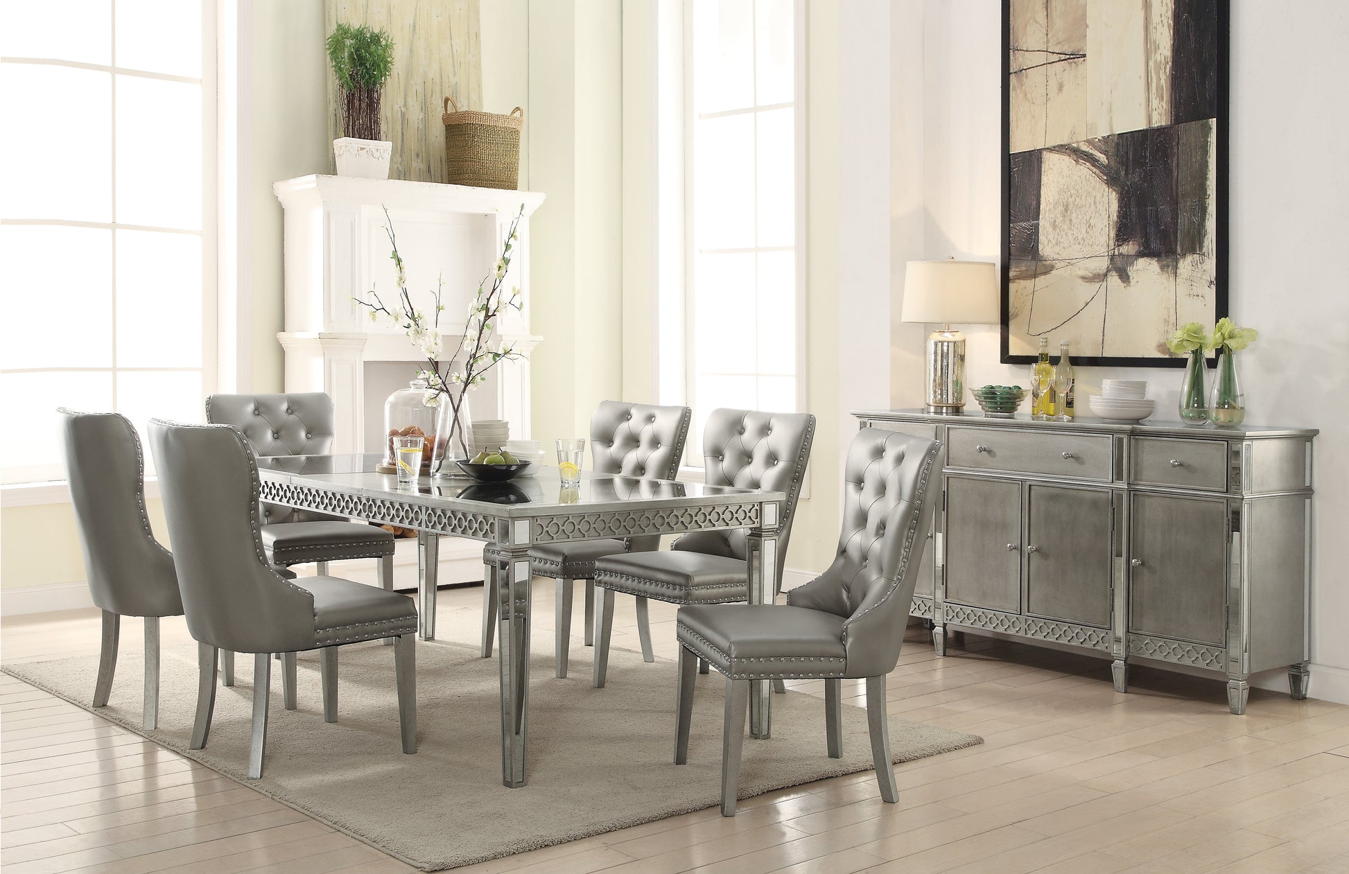 Silver tufted dining chairs and mirrored table set in elegant dining room