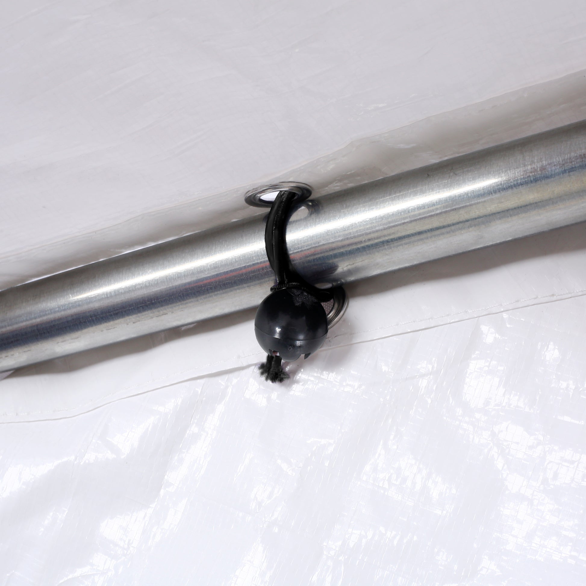 White tarp grommet with bungee cord and ball for secure attachment