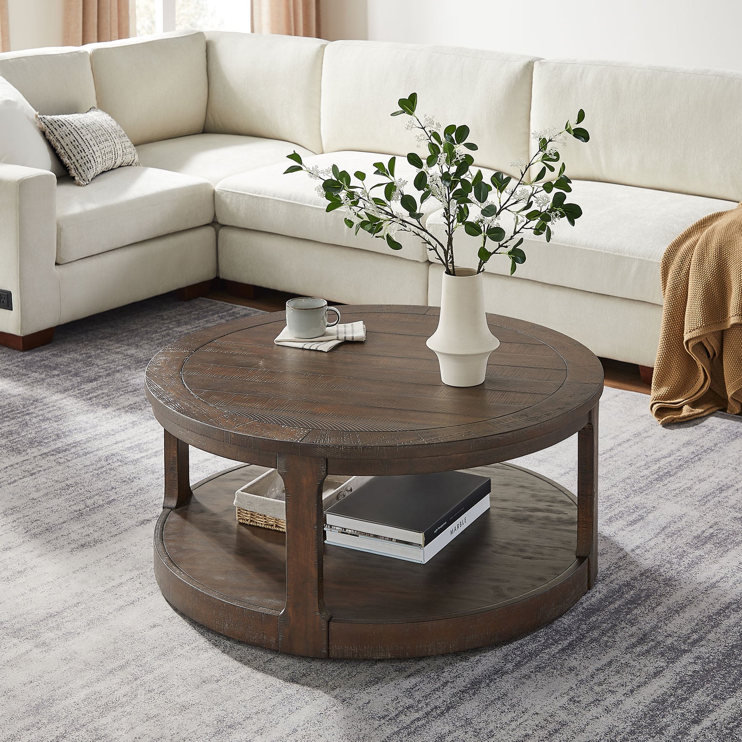 Round dark wood coffee table with distressed finish and lower shelf