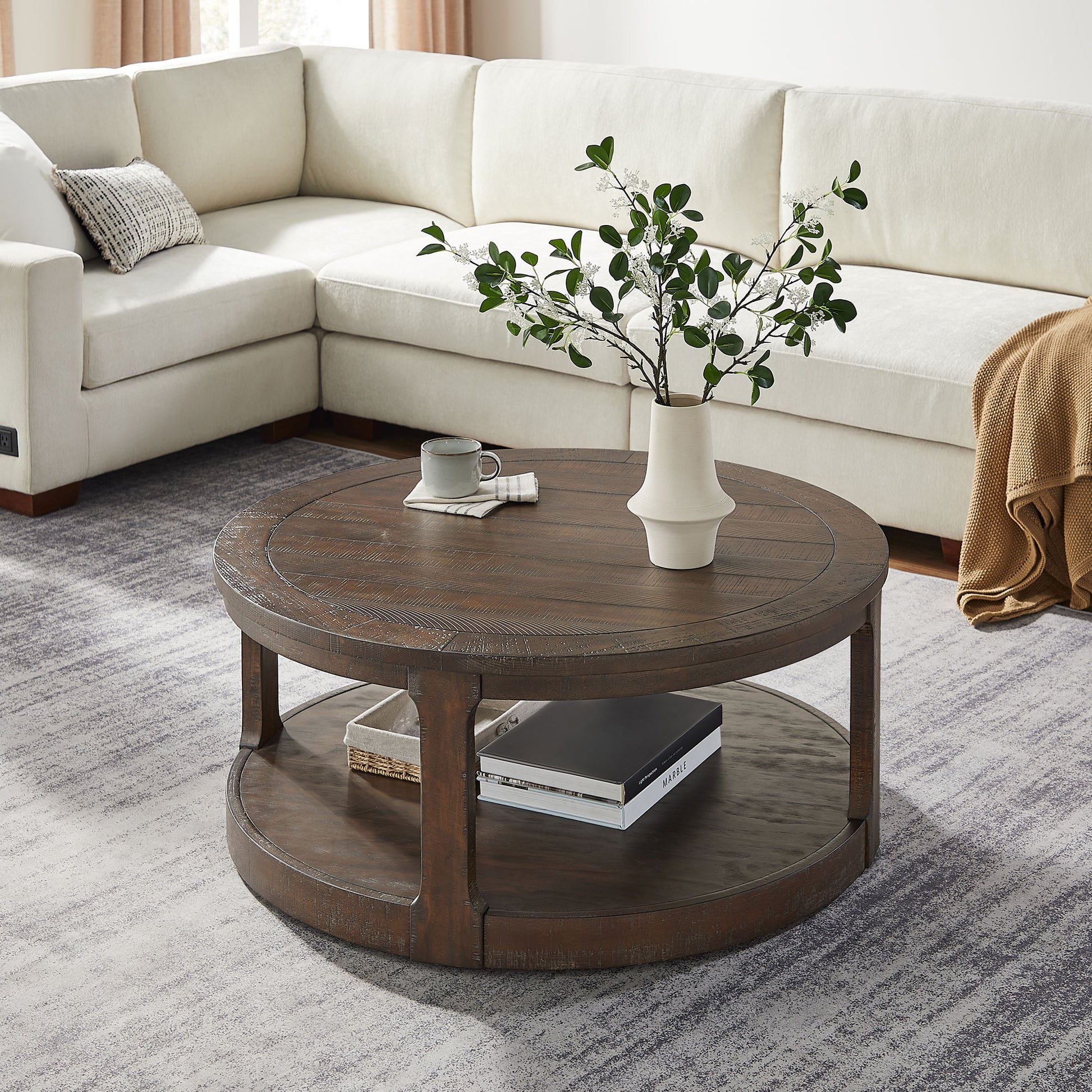 Round dark wood coffee table with distressed finish and lower shelf