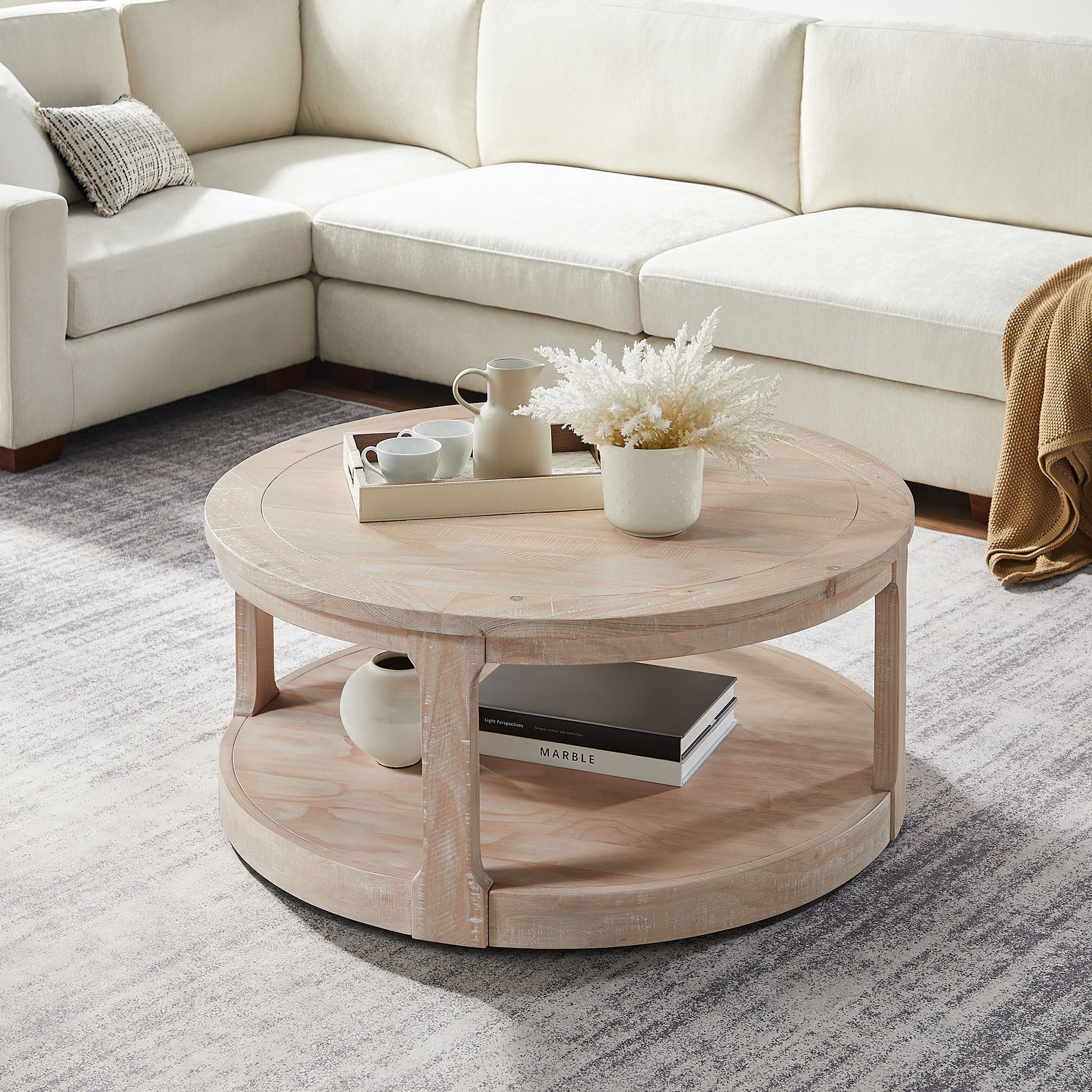 Round distressed wood coffee table with two tiers and a light wood finish