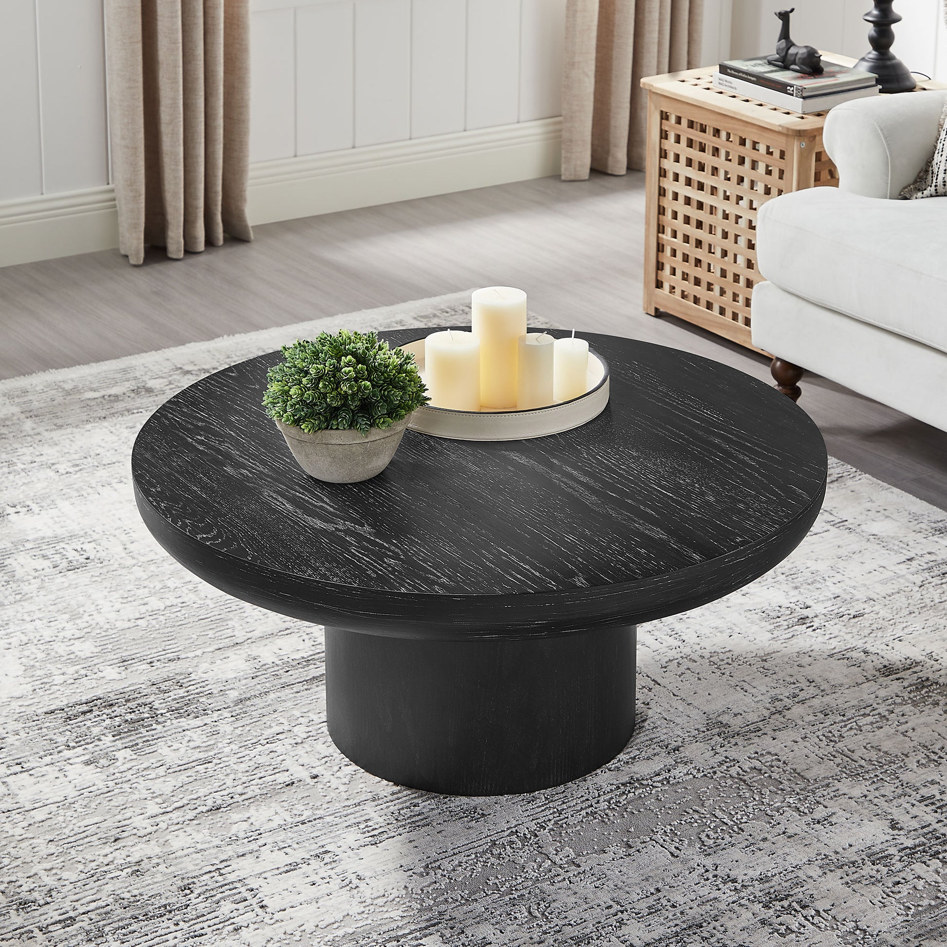 Round black wood coffee table with distressed finish and pedestal base central living room accent