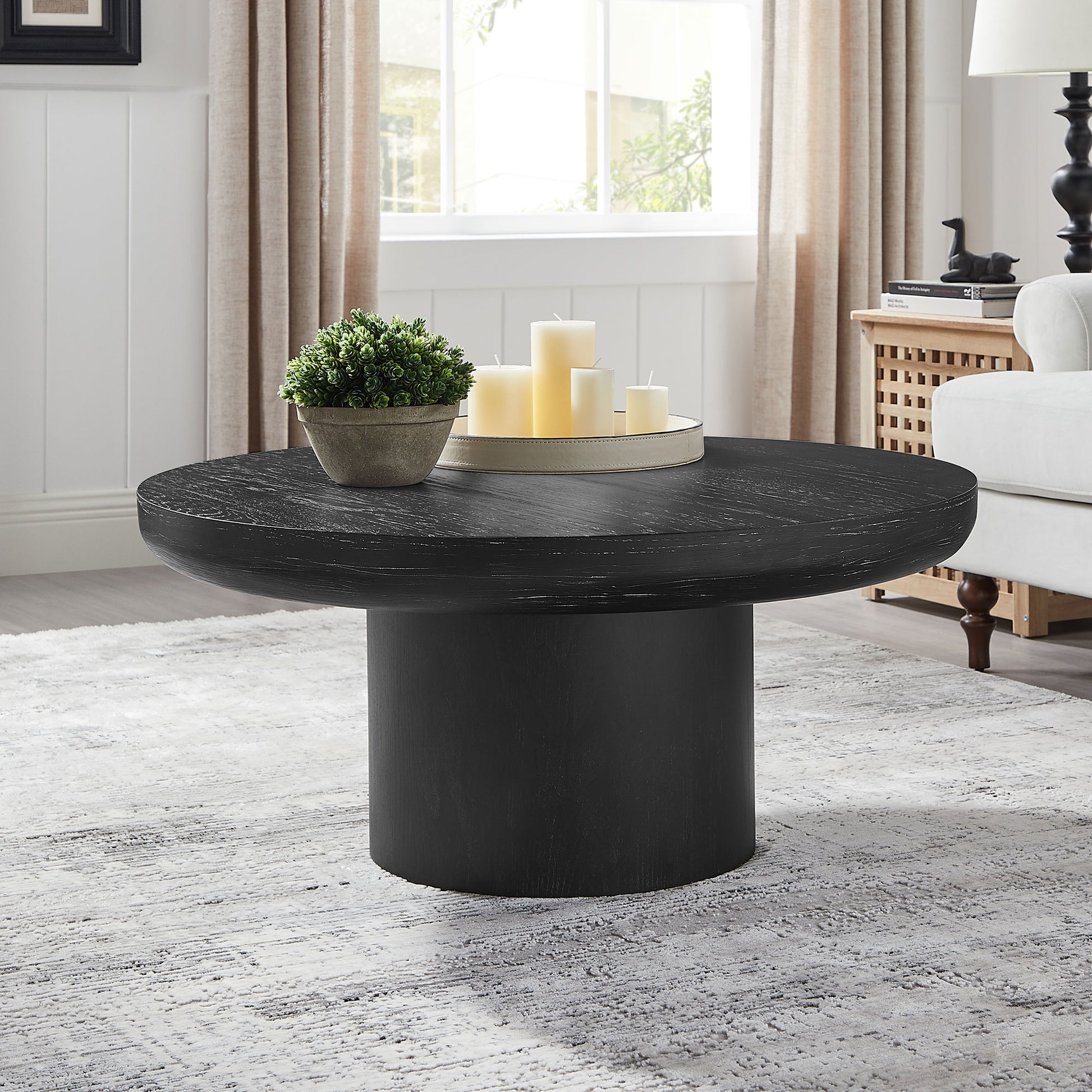 Round black wood coffee table with textured surface and cylindrical base ideal for modern living rooms