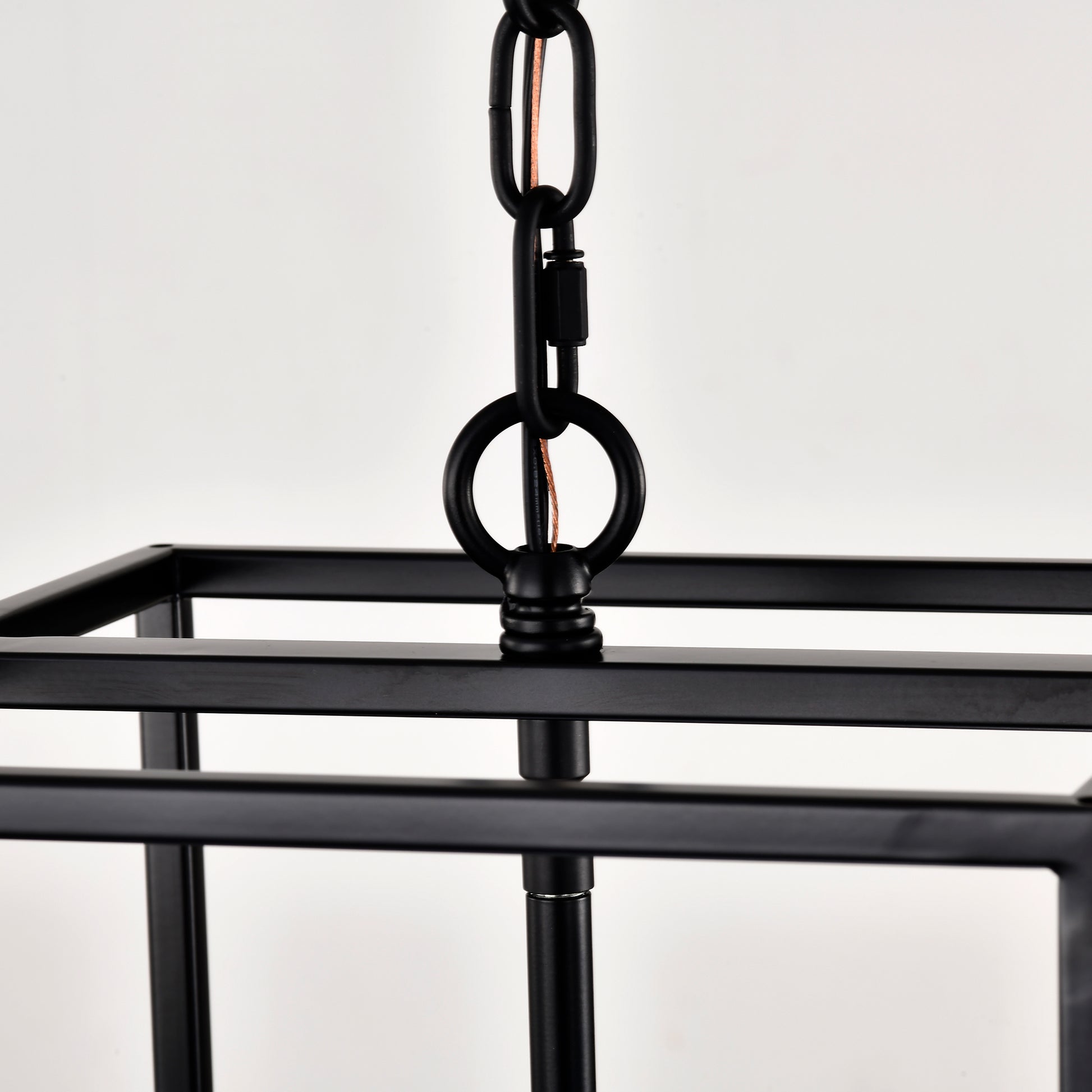 Closeup of a black rectangular cage chandelier with metal chain for hanging